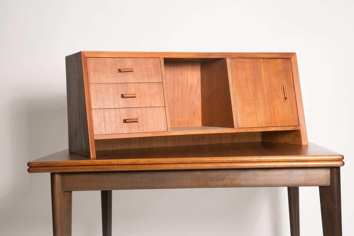 Handsome Danish teak office hutch. Three small cabinets on the right side and a larger one the left side separated by an open display space. Turn a table in a secretary. Ideal on dressers, credenzas, tables. Very good vintage condition. 
Depth 8.5