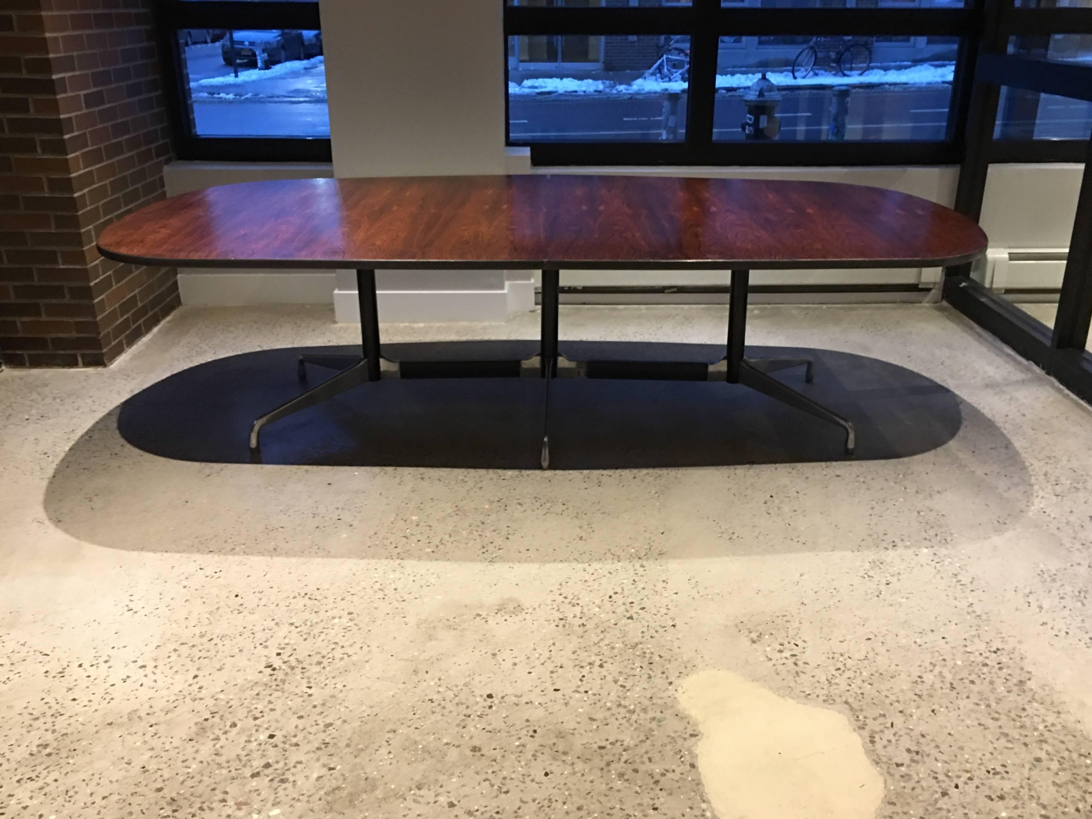 9 foot long spectacular Herman Miller Eames dining or conference table in Brazilian Rosewood. Gorgeous depth of color and highly figured rosewood grain patterns. Rests on polished aluminium segmented base with all original glides. Worldwide shipping