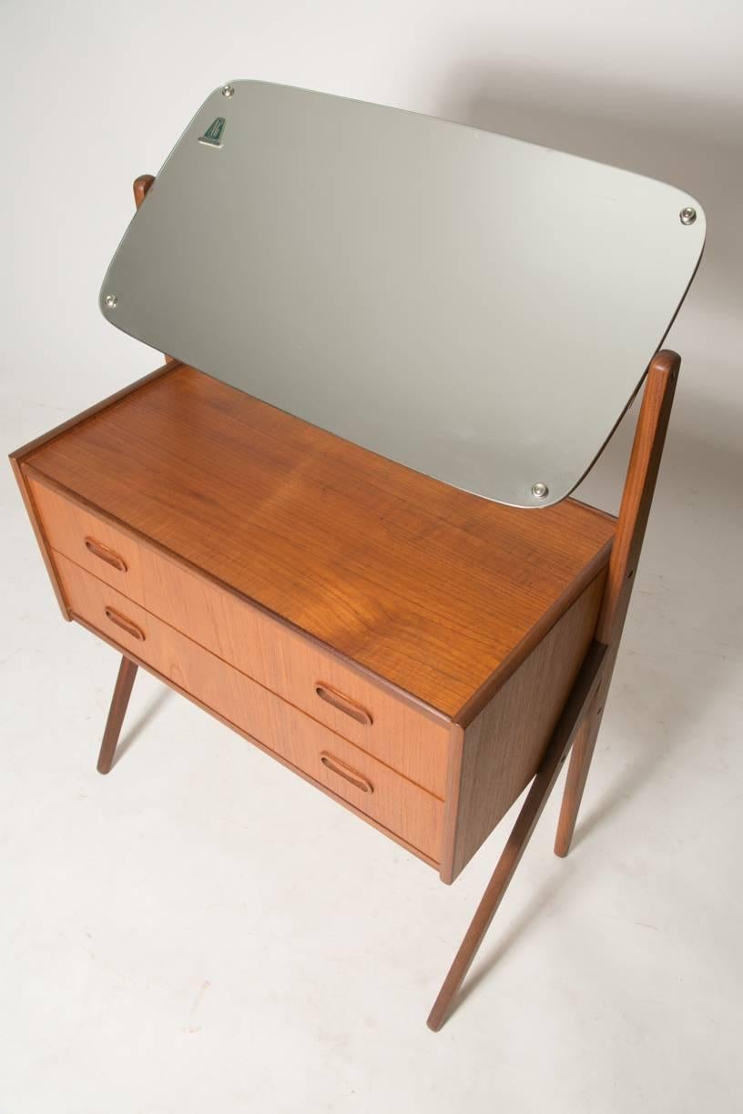 Graceful modern vanity offers a compact but great capacity of storage, built by A.G. Spelj Kobberskyttet, circa 1960. Very modern style with elegant pulls and a swiveling mirror. Piece is in excellent condition.

27.25 inches wide 
14.5 inches