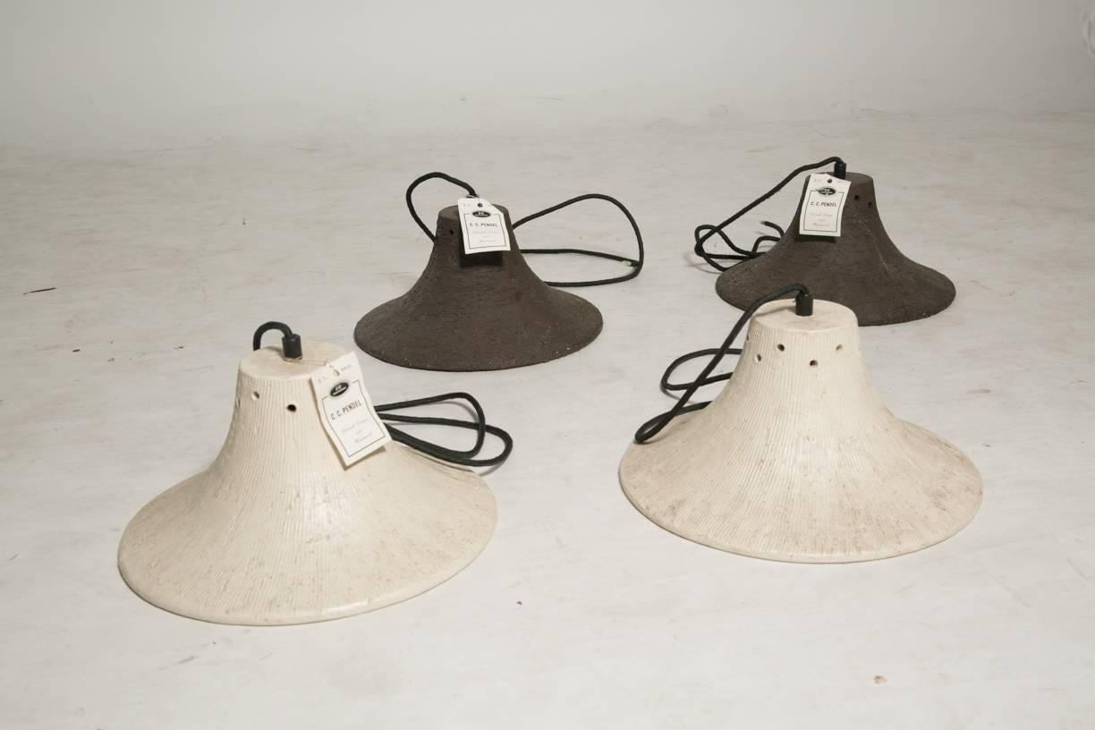 Vintage Studio Pottery stoneware light fixtures. two in textured earth with vibrant red enameled interiors and two in bone and earth with red enameled interiors. these lights are dead stock never installed with tags in place. elegant and rustic