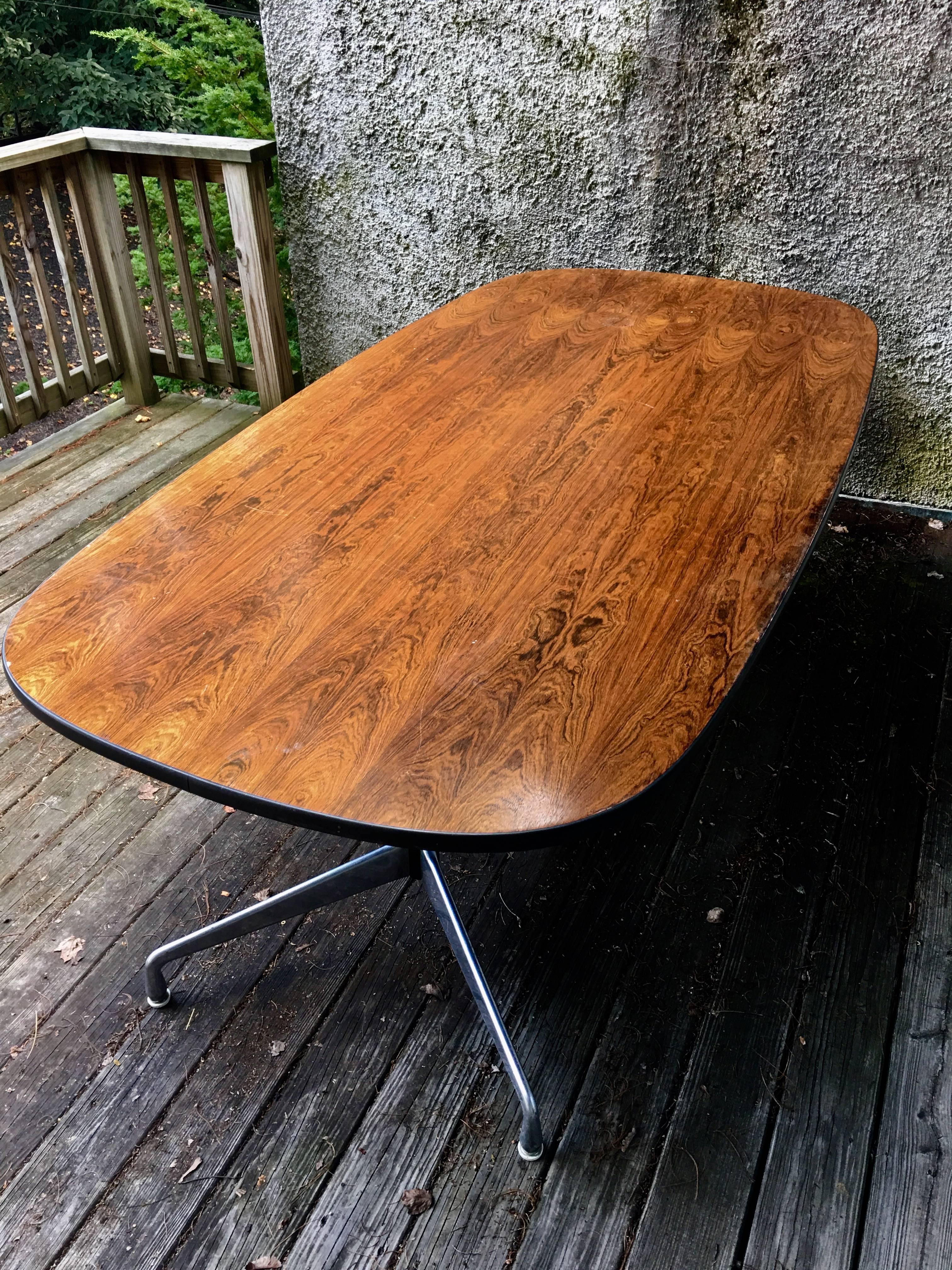 Herman Miller Eames rosewood conference or dining table. Fits eight-ten chairs. In very good condition. Gorgeous wood grain patterns and color.