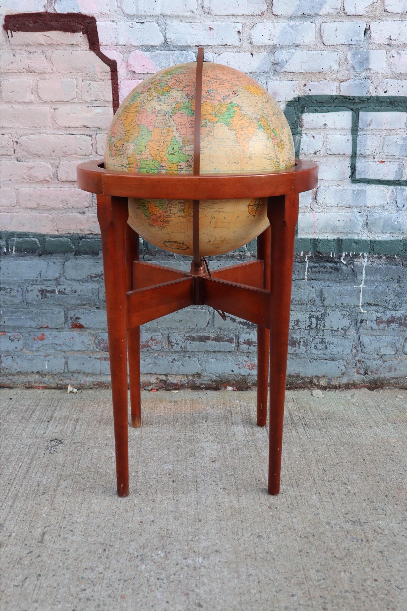 Beautiful glow or glowing globe by Replogle. Elegant lines on strudel wooden frame with sculptural tapered legs. The globe ball stands upright but is also adjustable to 23.5 degrees to mimic actual axis. Gorgeous warm glowing effect at night. Can be