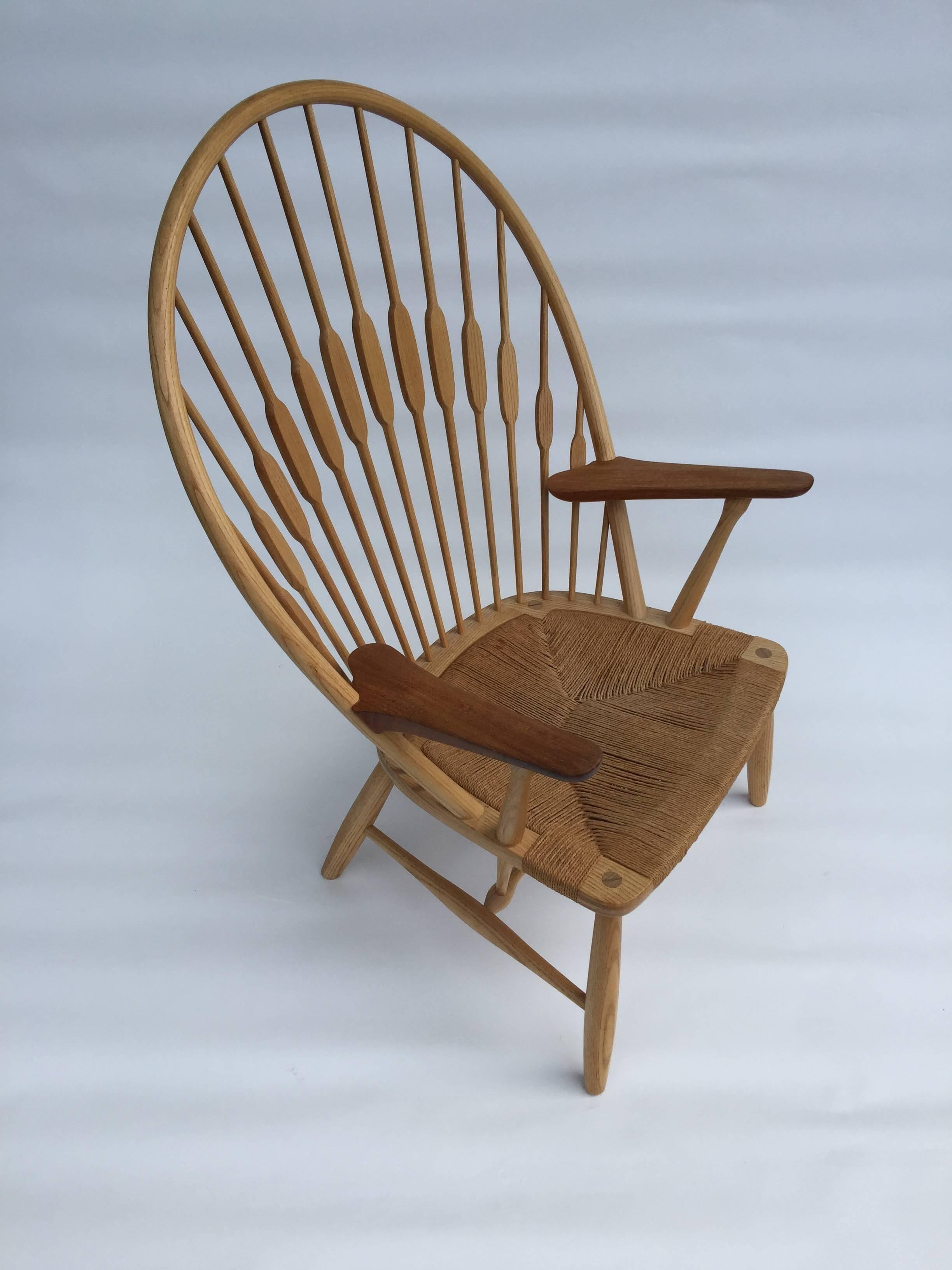 Hans Wegner peacock chair designed in 1947 features a Windsor back in oak with teak arms and detail. Produced by Johannes Hansen with signature.