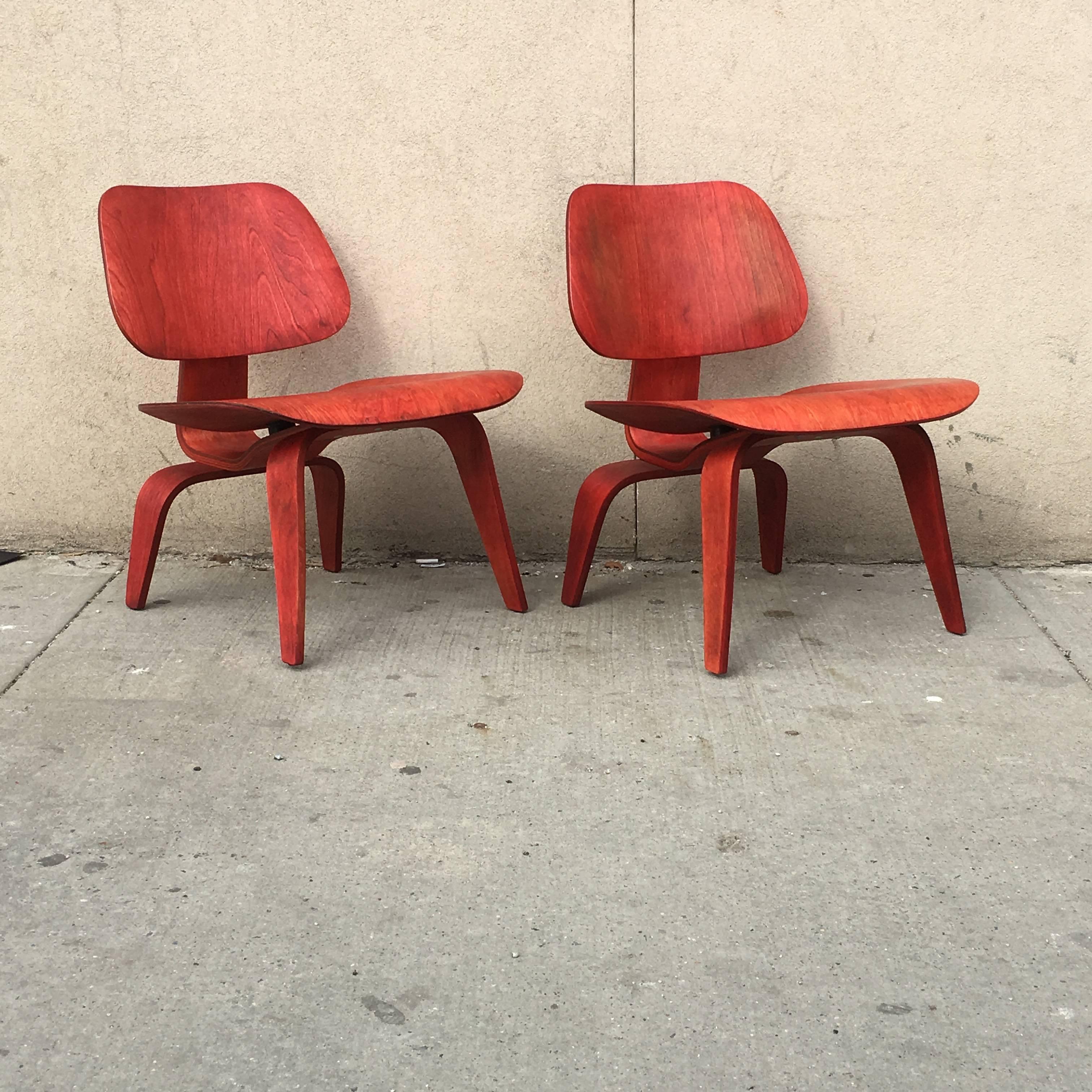 Two early Eames LCWs manufactured by Evans Products in the 1940s. Rare red version of the iconic chair. Chairs are structurally sound and in great shape given age. Shock mounts reglued at some point. Bright vibrant red aniline dye on birch veneers.