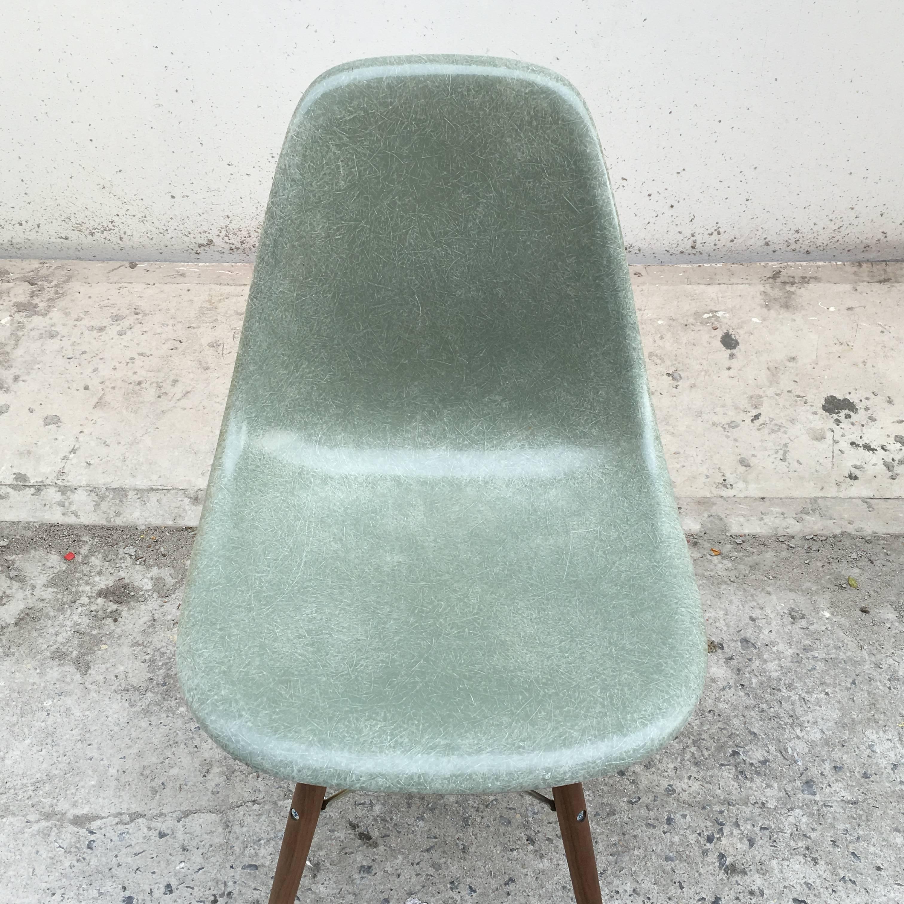 Eight Herman Miller Eames seafoam green dining chairs. In great vintage condition with no cracks or holes. Large sets in this color are hard to source. The bases are from modern conscience and feature zinc coated steel rods and walnut dowel legs.