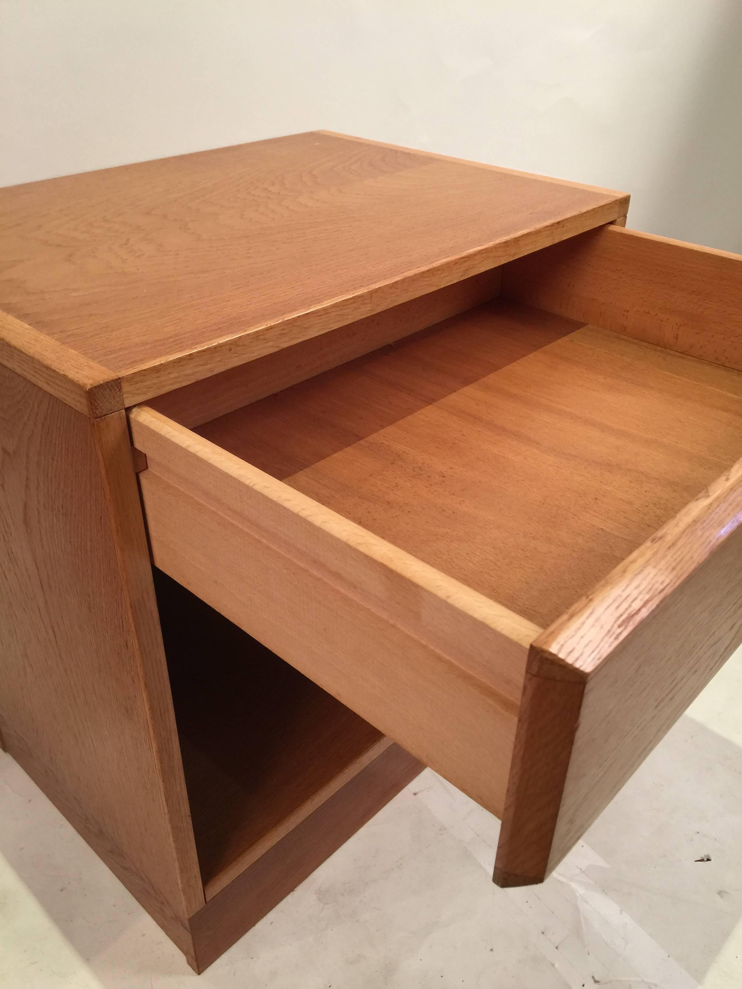 Simple pair of teak nightstand with drawers and open storage underneath. Clear coat finish and bevelled fronts. Danish maker's mark tag on the back of the nightstands. Good vintage condition, showing minimal wear, except one heat stain on top of one