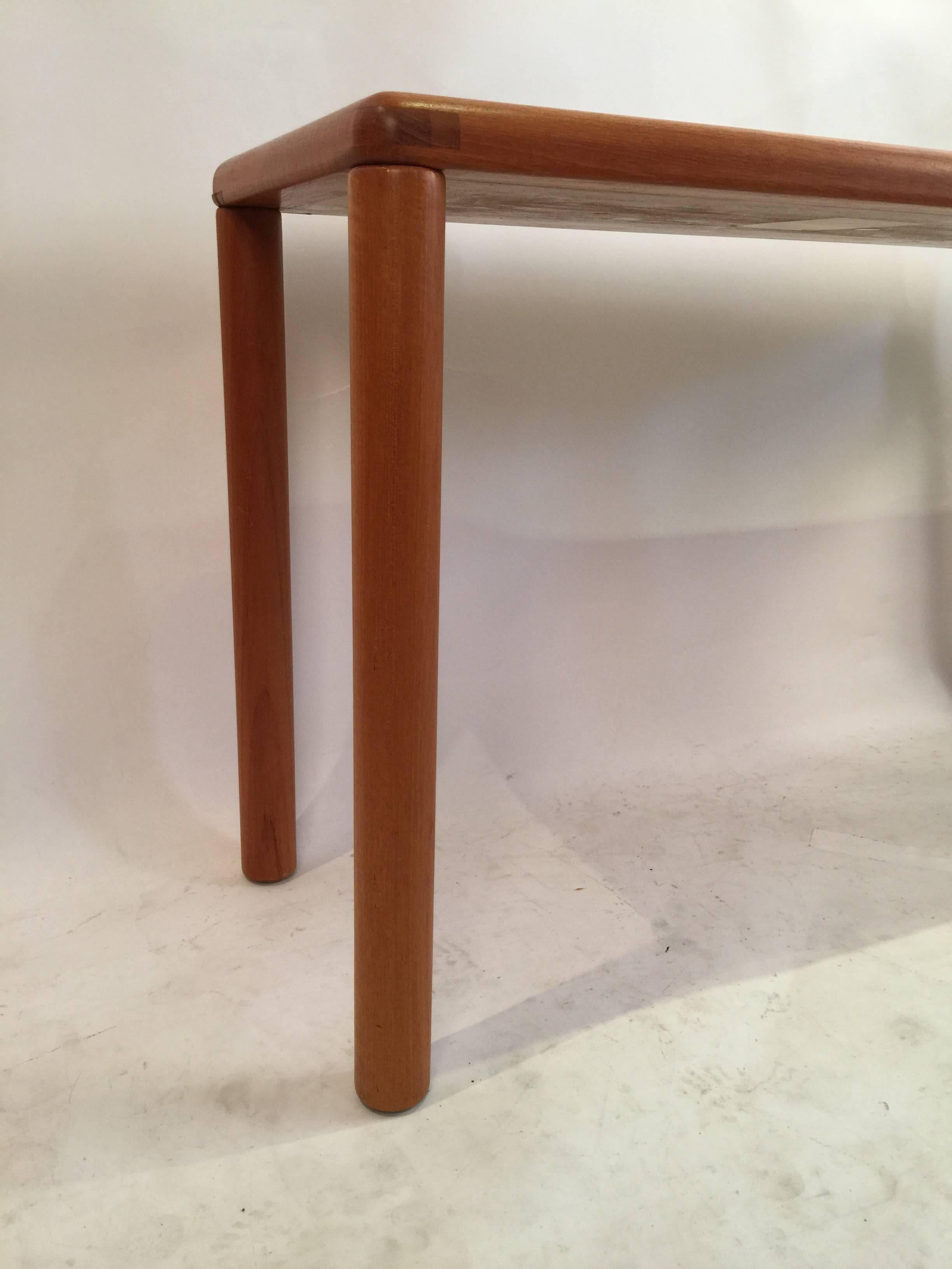 Console table of solid teak manufactured by Haslev in 1985 with slate tile top. This versatile size will make a great sofa table, entry way or any variety of uses. Durable natural slate tiles are encased in a teak frame with solid dowel legs.
  