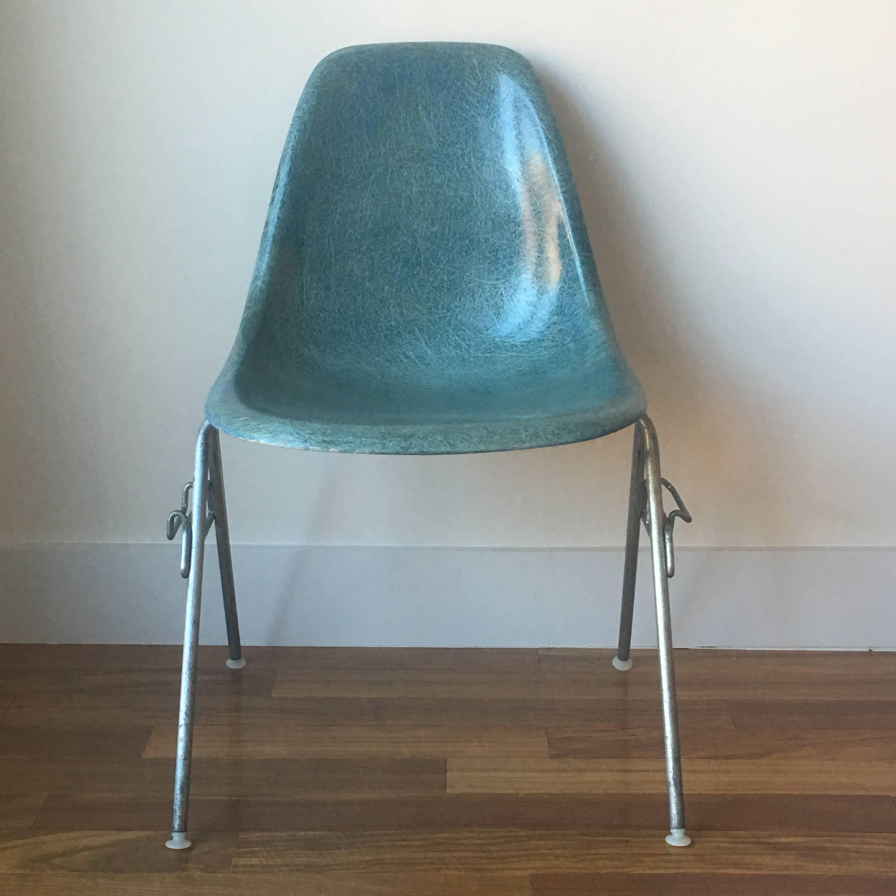 Four Herman Miller Eames fiberglass chairs in very rare colors. No cracks or structural issues. Some fading from general use. A special set. The chairs feature stackable bases. All bases have glides intact.