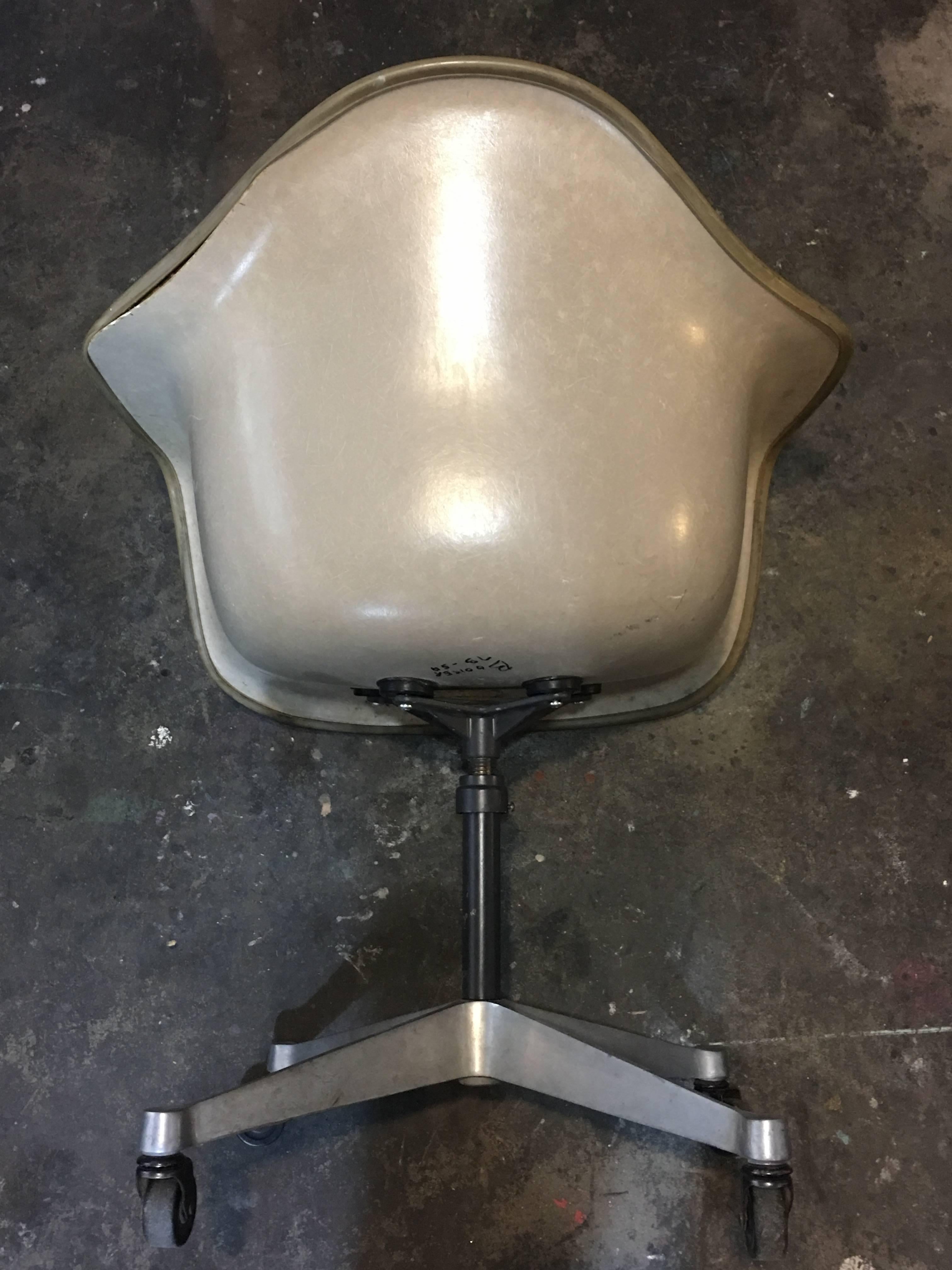 Herman Miller Eames swive armchair. Vinyl upholstery in excellent condition. Base perfect. Swivels and height adjusts. Greige fiberglass with all original shock mounts. Piping coming off the back edge a little bit can be fixed.