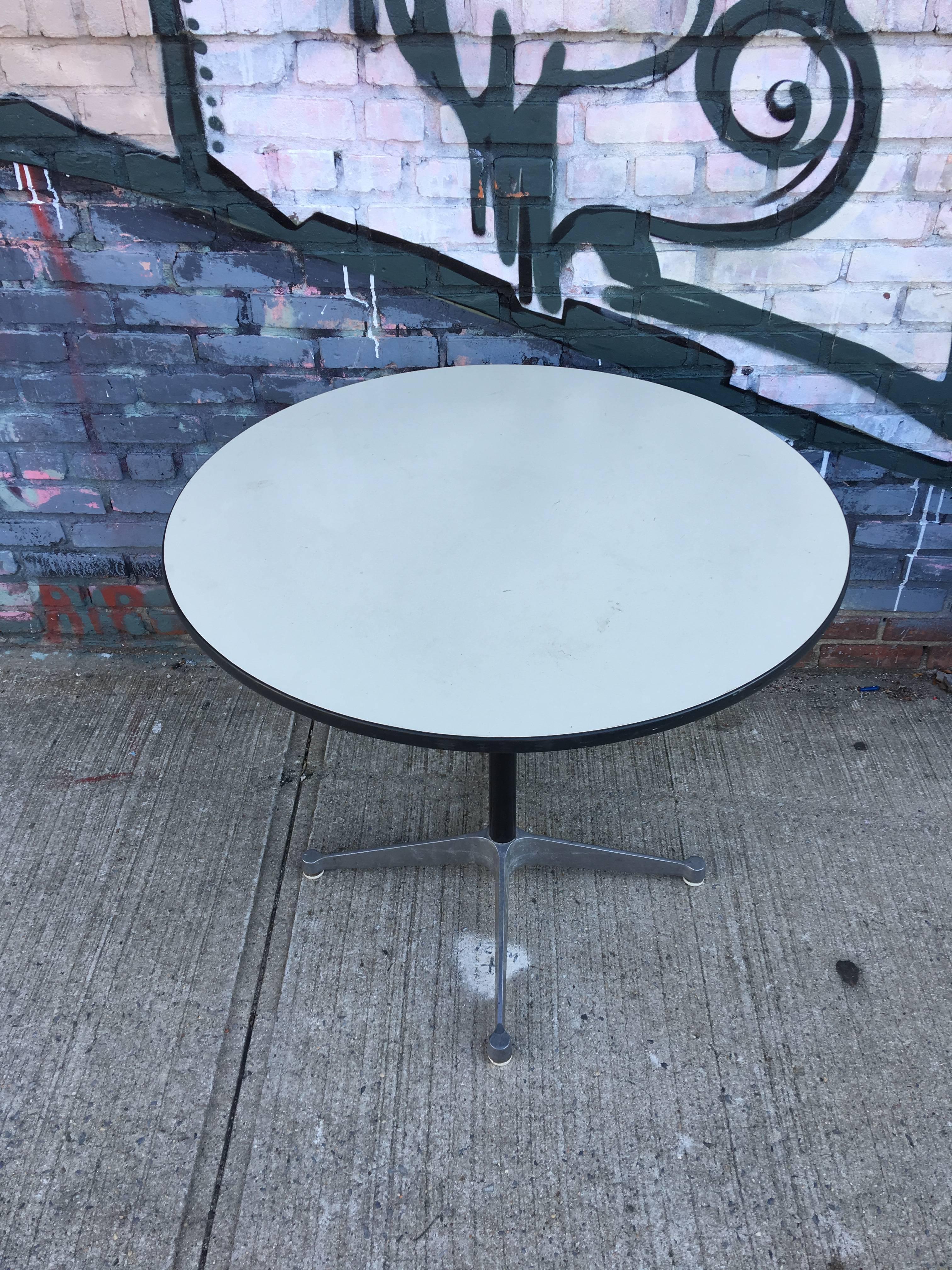 Herman Miller Eames 36 inch dining table. White laminate top. Aluminium base with tag on pedestal. Signed Herman Miller underneath. Easily fits two-four chairs.