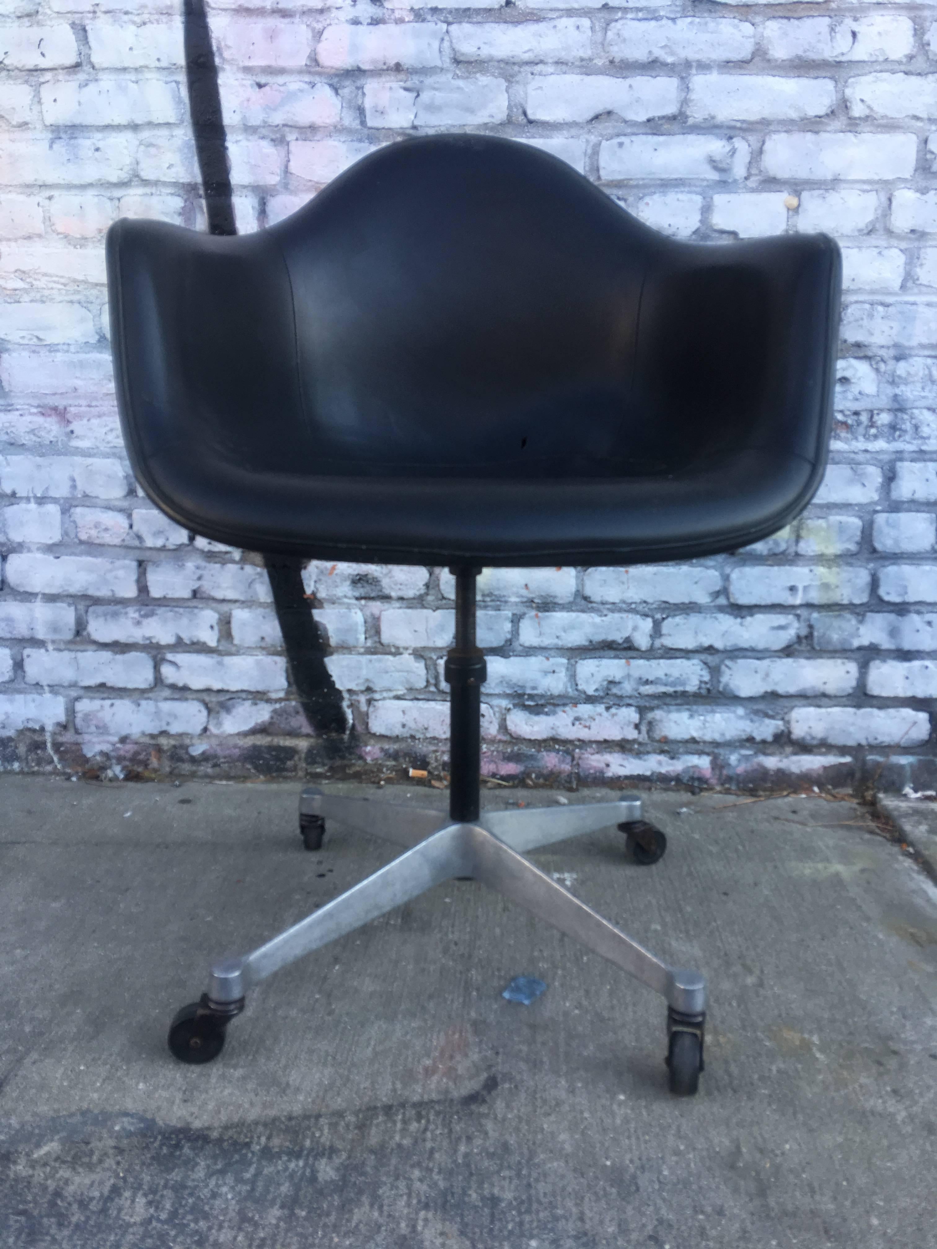 Black on black Herman Miller Eames fiberglass armchair with naugahyde upholstery. In excellent condition with one small slit in vinyl. Piping intact with no separation.
