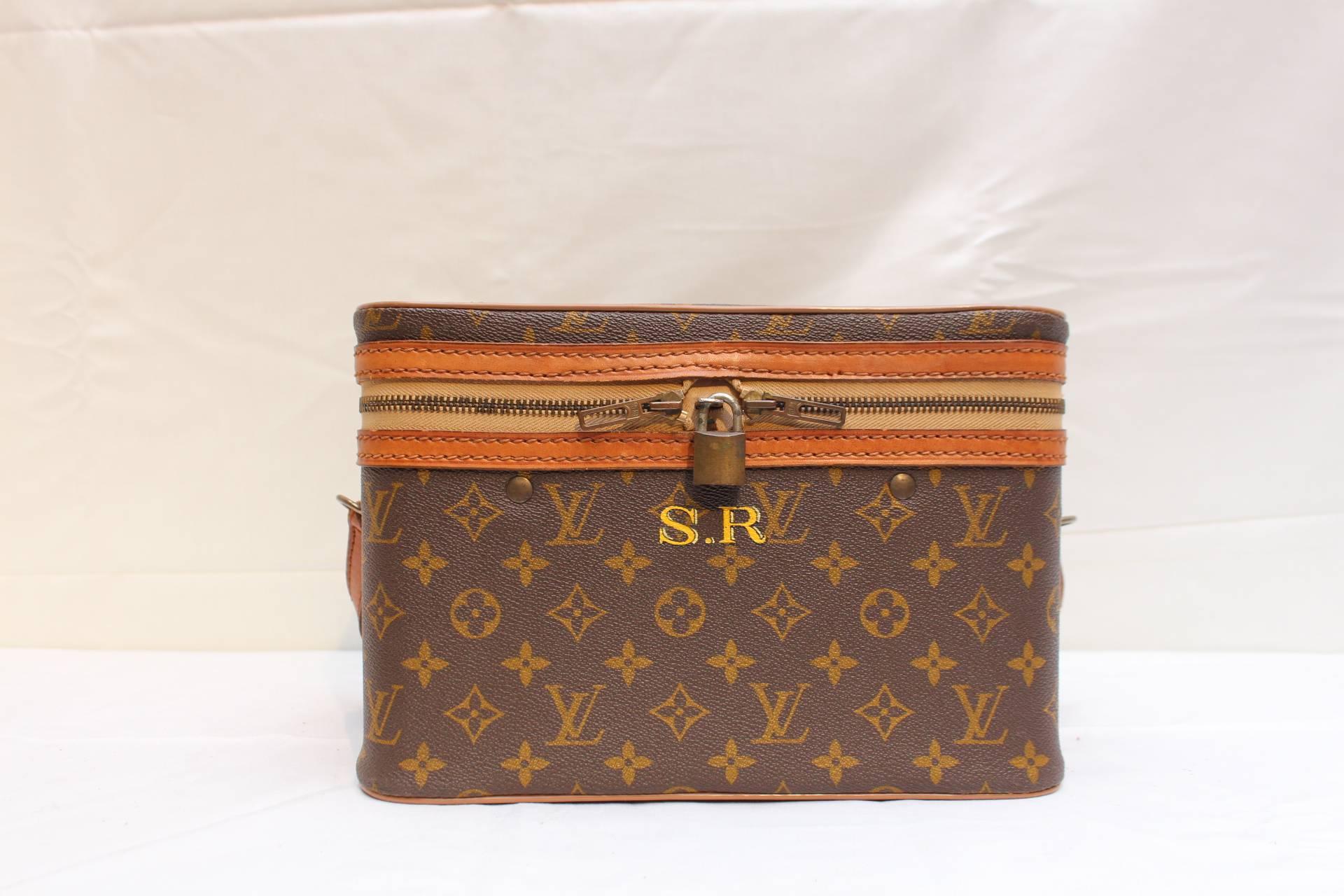 The iconic Louis Vuitton vanity case in the classic monogram with golden brass locker. The interior in a cream fabric with three holders and two pockets. The handle is in leather. 
Key is missing.