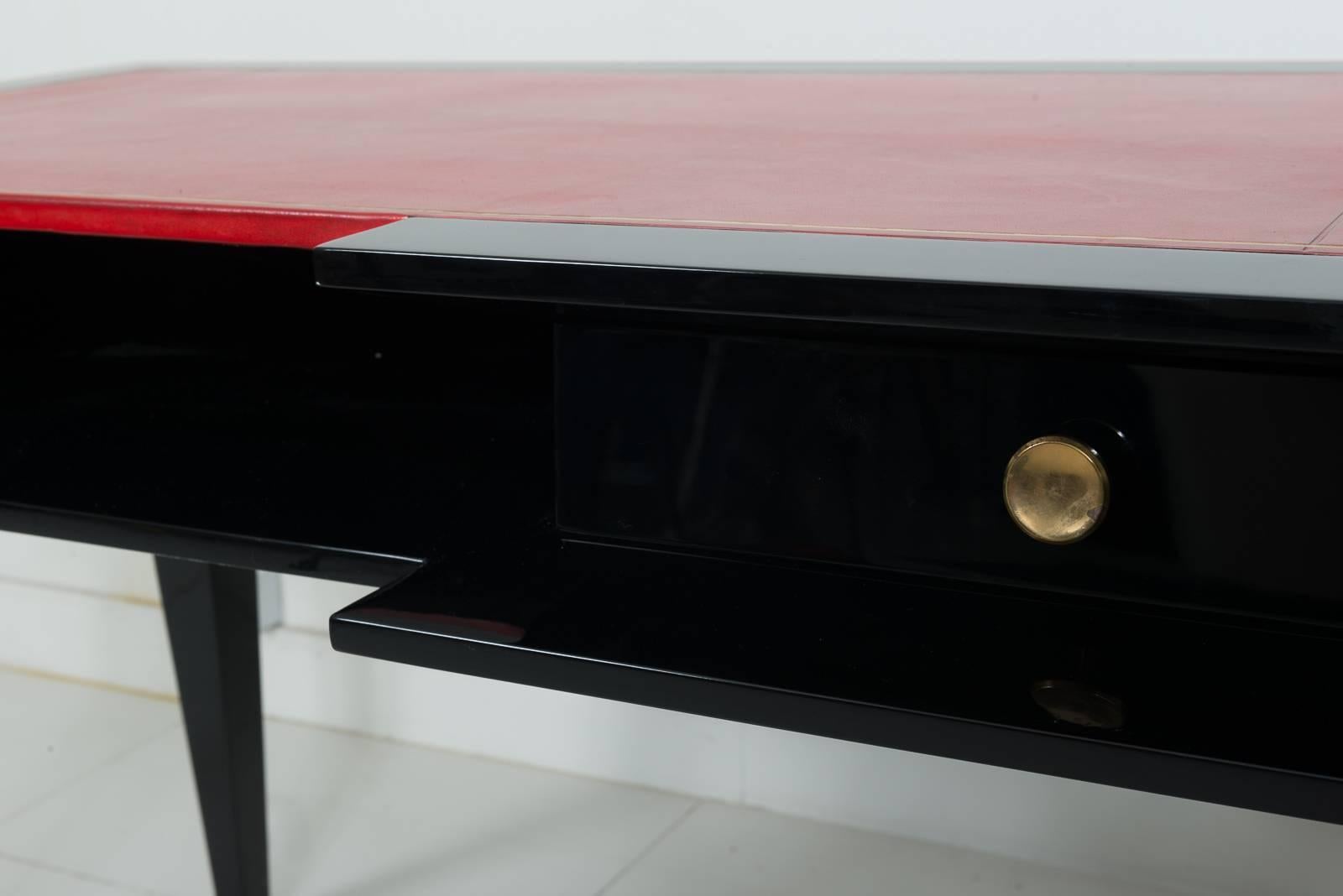 Writing Desk in a Black Lacquer and an authentic Red Leather on the top with a Modernist Lignes and Shapes, circa 1950.
