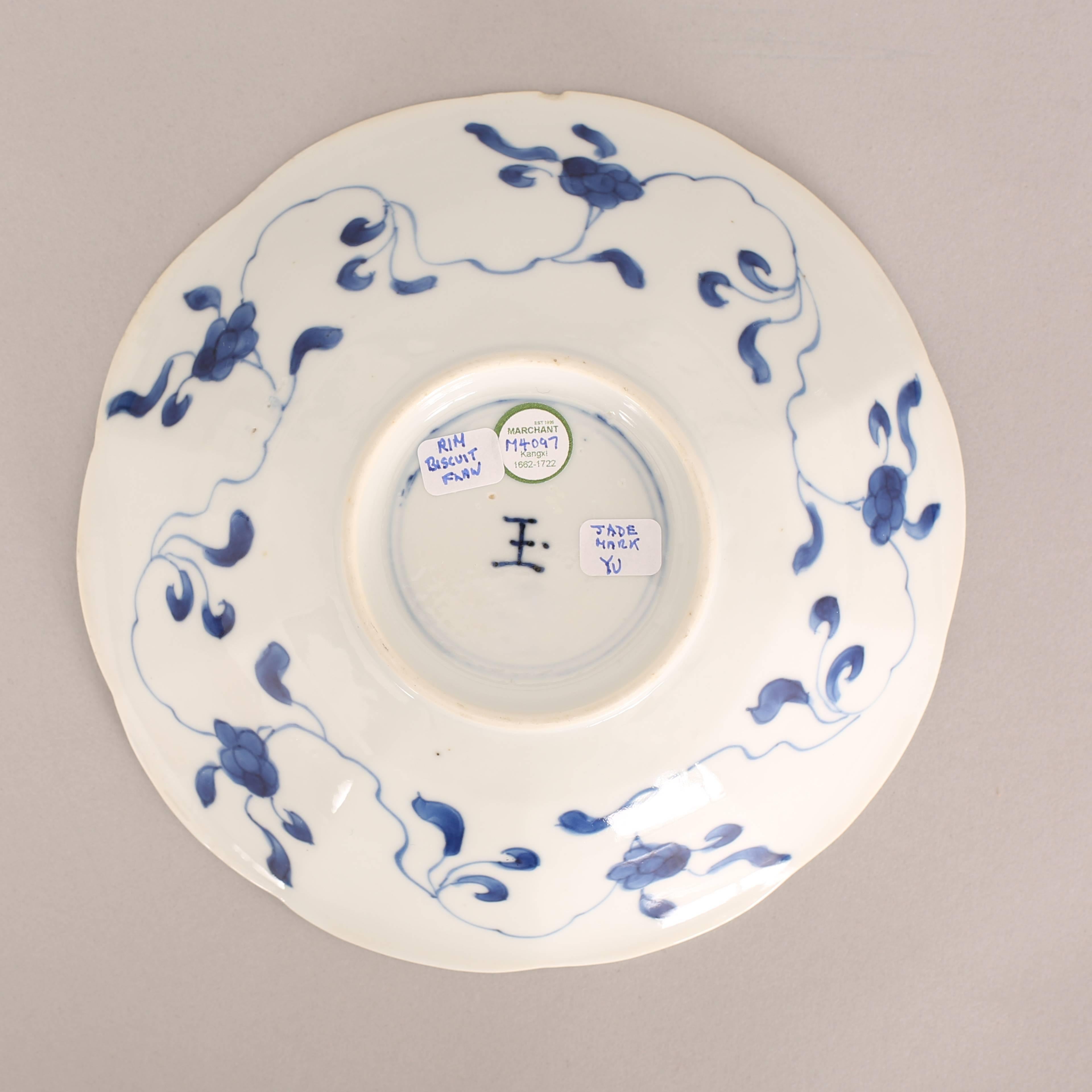 A Chinese porcelain blue and white saucer dish of lobed form, painted with ten paneled scenes of women and flowers, encircling a central medallion with a seated lady beside a plant on a small table, the underside painted with a continuous floral