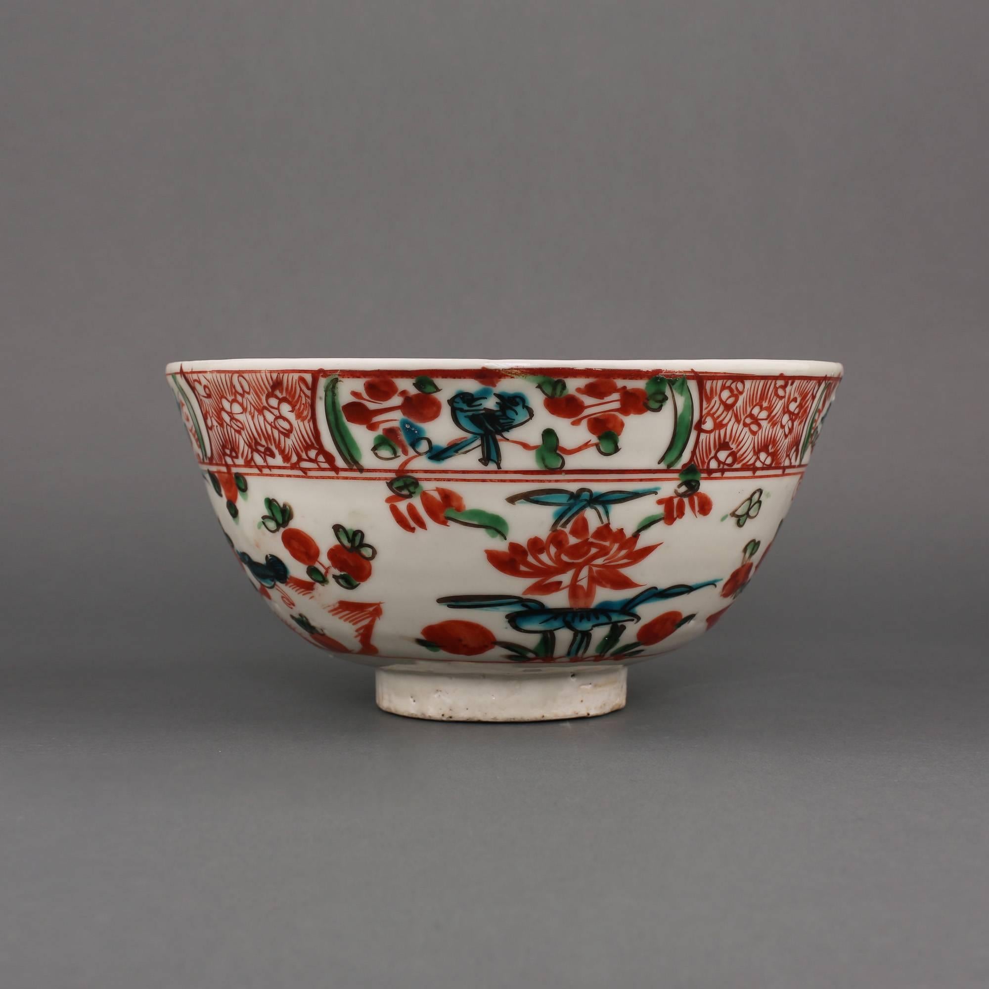 A Swatow Chinese porcelain wucai bowl painted on the exterior in iron red, green and turquoise enamels with birds and flowers beneath a floral band divided by four panels of pairs of birds, flowers and rabbits, the interior with a single flowerhead