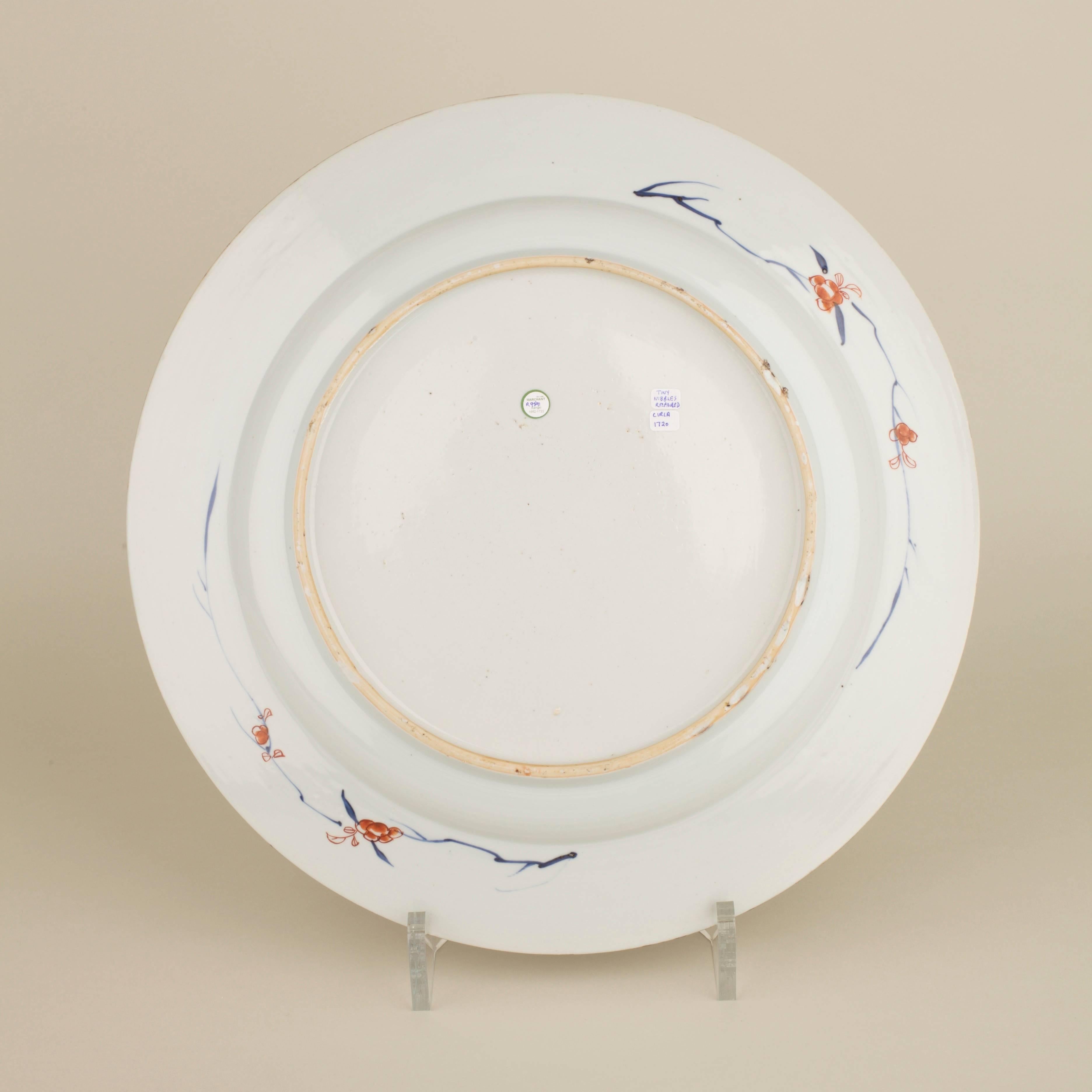 Chinese porcelain underglaze blue and white large plate with flat everted rim painted in the centre with a lady and two boys in a fenced garden scene, the lady picking flowers from a tree whilst the boys play beside a fence, all surrounded by