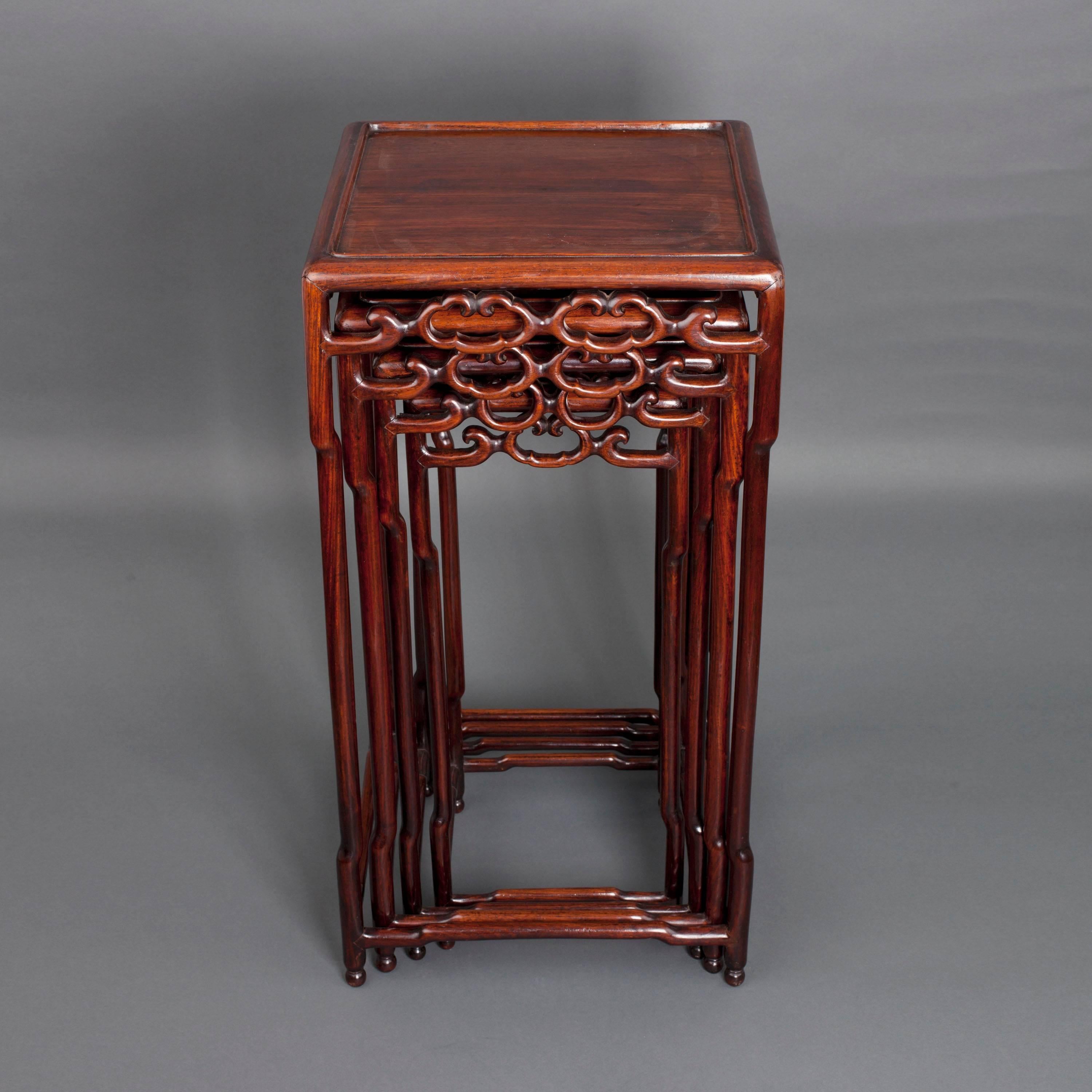 A Chinese hongmu nest of four square tables, the frieze in the form of open ruyi-heads, the tubular legs and lower cross joins with raised sections,

circa 1900.

Measure: 73 cm high, 37 cm wide, 37 cm deep.