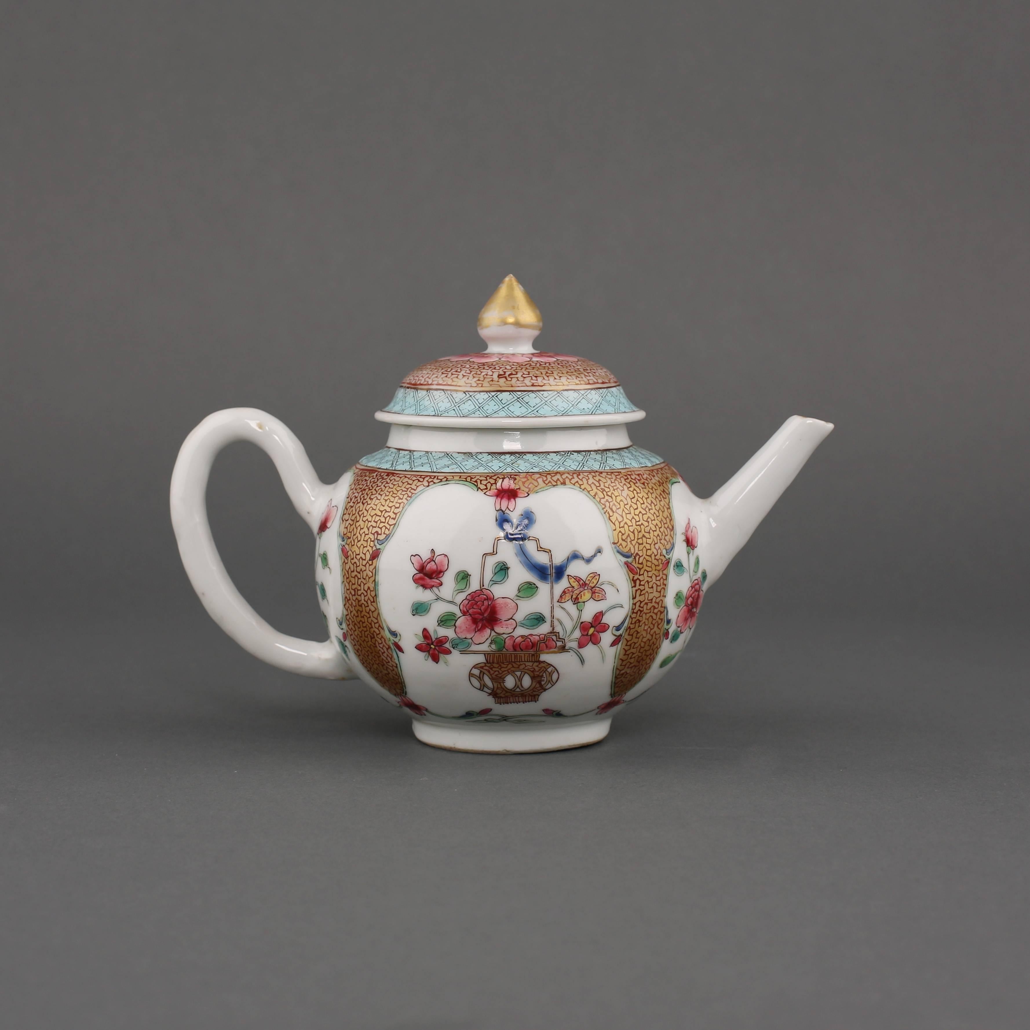 A Chinese porcelain famille rose globular teapot and cover, painted on either side with a foliate panel of a basket of flowers on a gilt ground with key fret pattern, two further panels at the handle and spout, all beneath a band of blue ground
