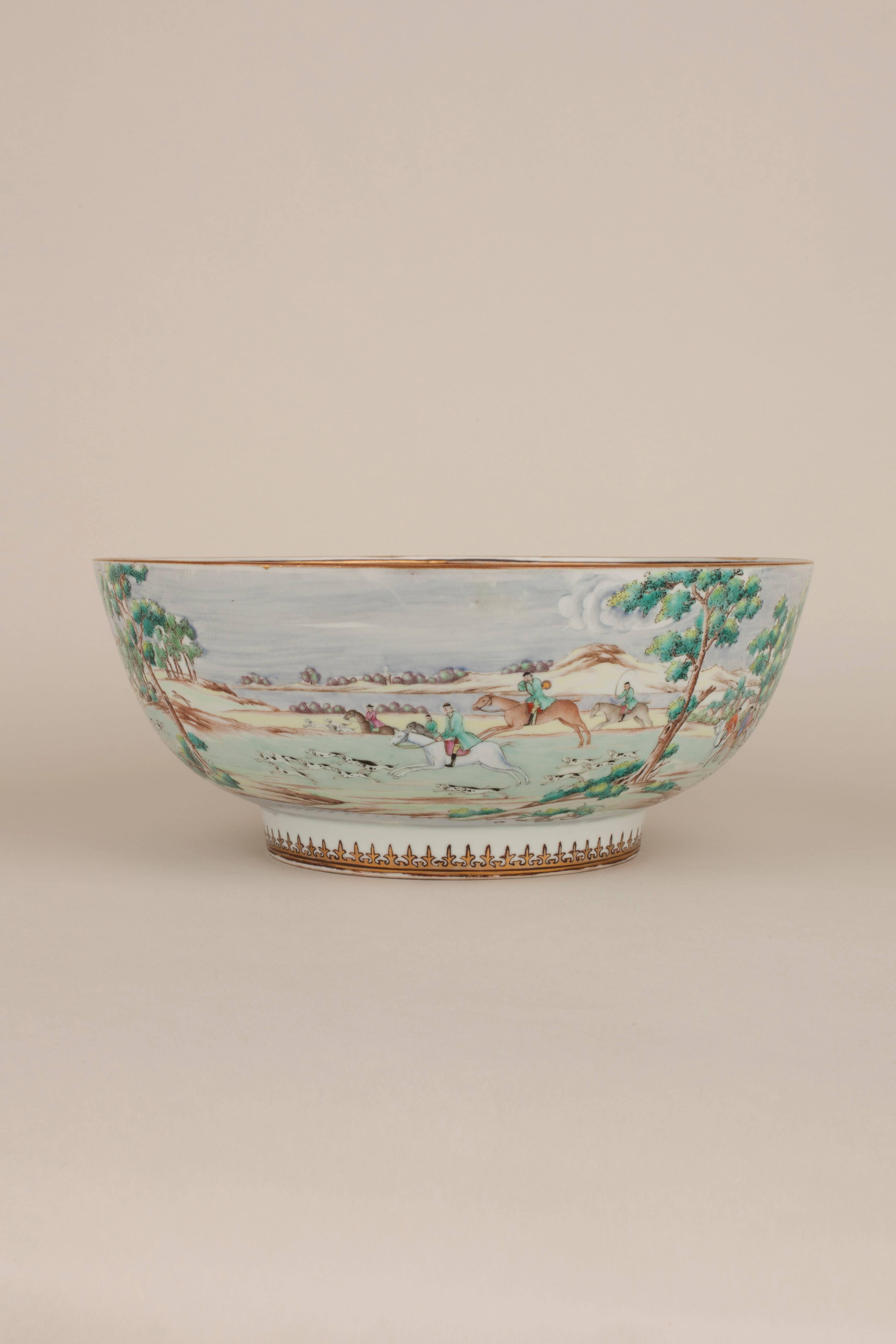 A Chinese porcelain famille rose English market hunting bowl, finely painted on the exterior after an original print by James Seymour, with a continuous scene of twenty-six equestrian riders with numerous dogs in a fox-hunt amongst buildings in a