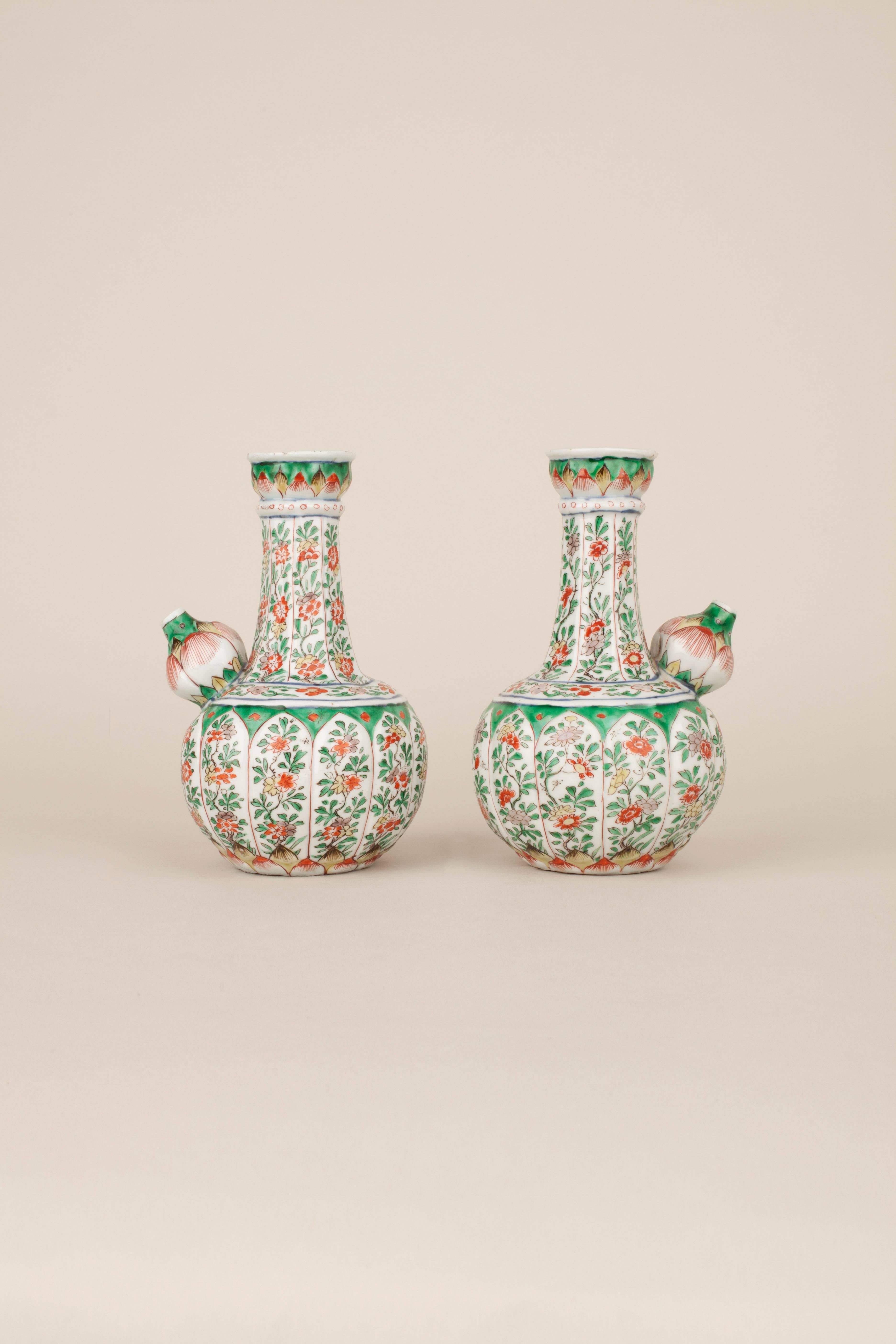 A pair of Chinese porcelain, famille verte moulded and fluted kendis.

A pair of Chinese porcelain, famille verte moulded and fluted kendis, the bodies of lotus flower form with twelve large petals each painted with branches of flowers, above two