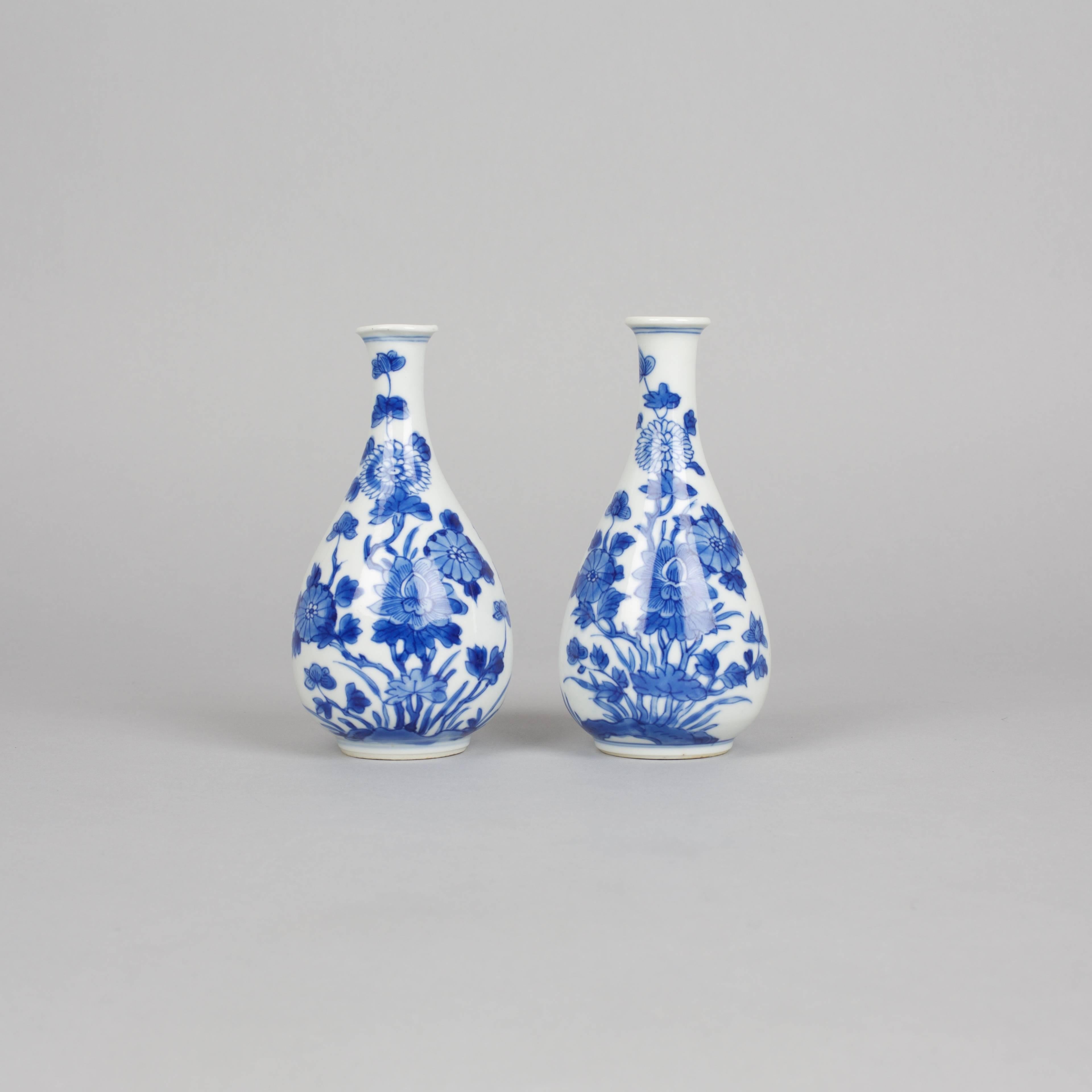 A pair of Chinese porcelain underglazed blue and white miniature bottle vases painted on either side with flowerheads emanating from foliage on the ground, all between double rings at the foot rim.
13.2 cm high, 6.5 cm width, 4cm foot