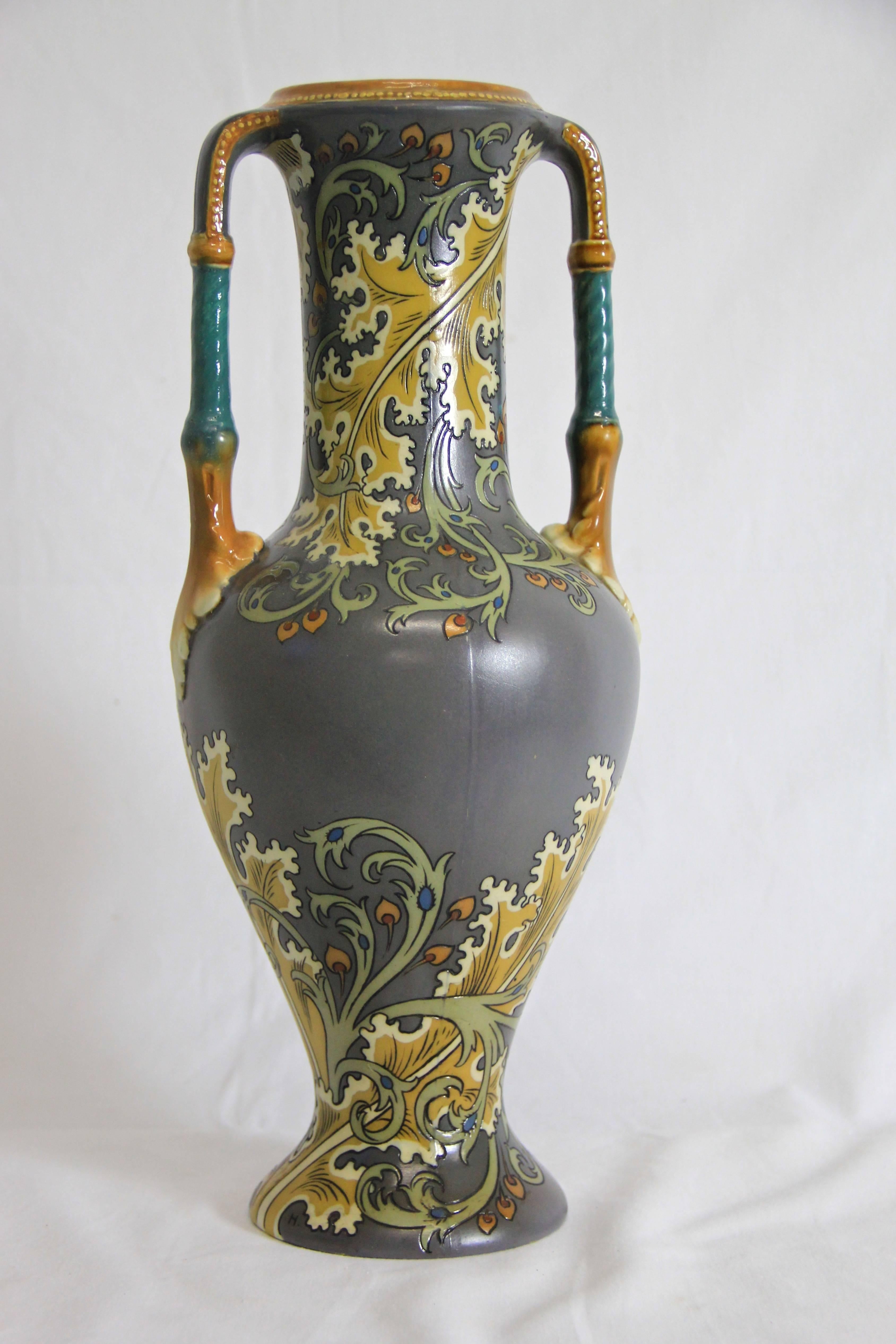 Mattes Grau:: schlanker Schnitt und ein ungewöhnliches:: aber sehr schönes florales Muster mit geschnittenen Konturen - diese Jugendstilvase stammt aus der Manufaktur Mettlach (heute Villeroy Boch):: Deutschland:: um 1900. 
Die beiden Griffe wurden