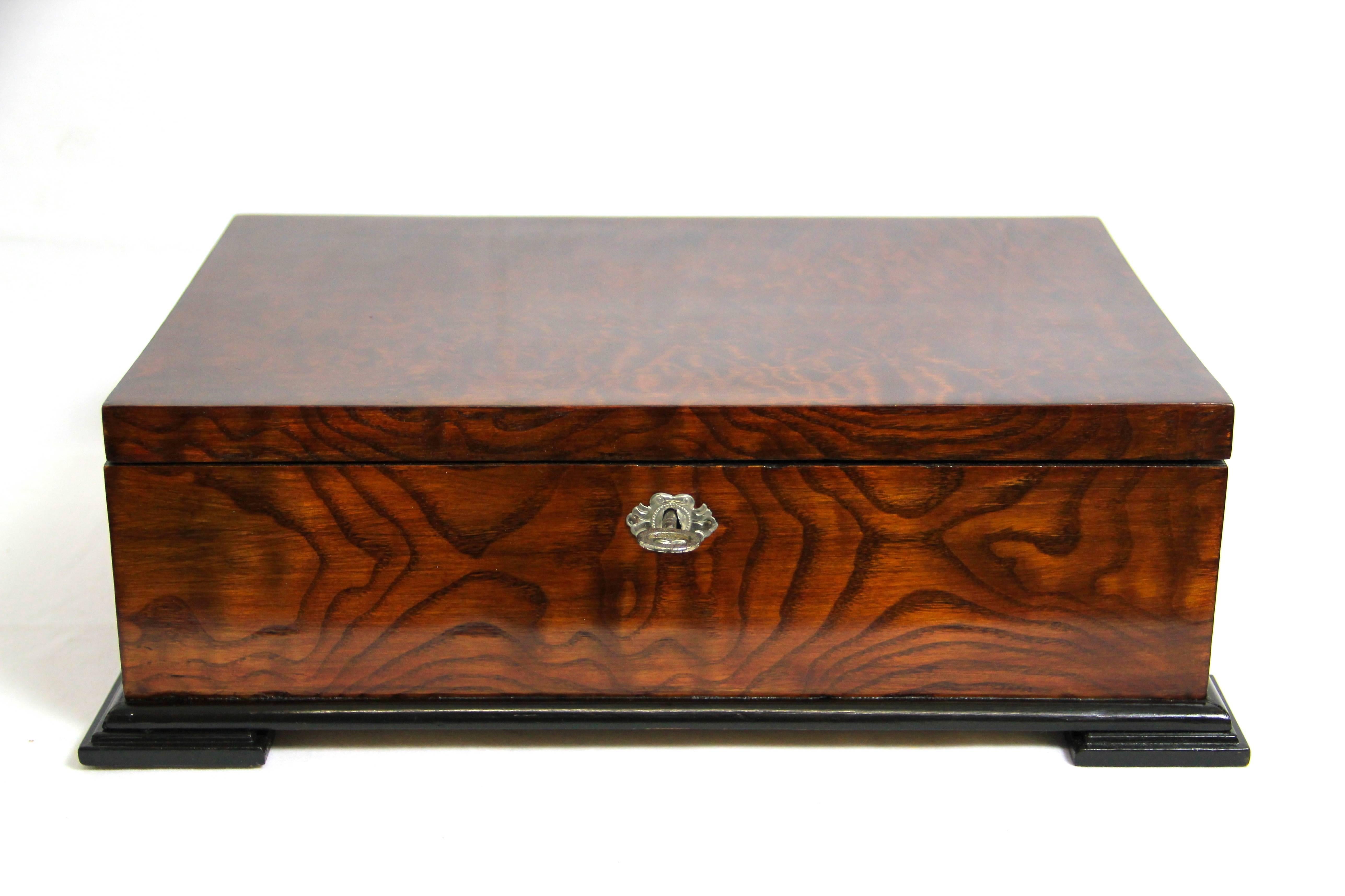 Wonderful wooden box from the Art Nouveau era. Amazing veneer work with tropical wood on the cover, ashwood on the body and nut wood inside - this decorative box can be used in many ways. The ebonized base builds a perfect harmony along the