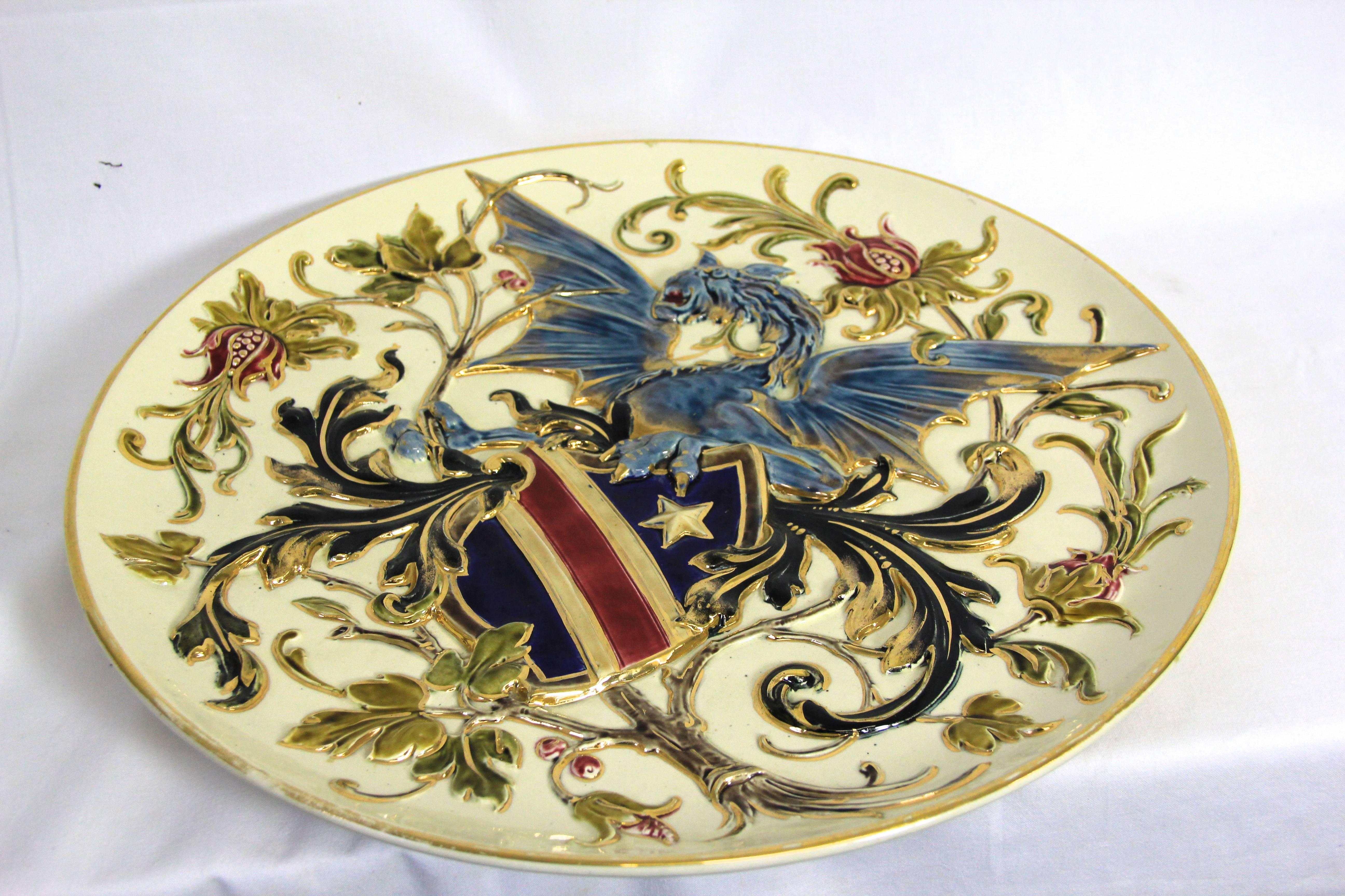 Large majestic wall plate decorated with a blue dragon and floral design in relief. The early Art Nouveau Majolica plate was painted in impressive colors to make it a perfect wall decoration. On the bottom there is an unreadable hallmark but it can