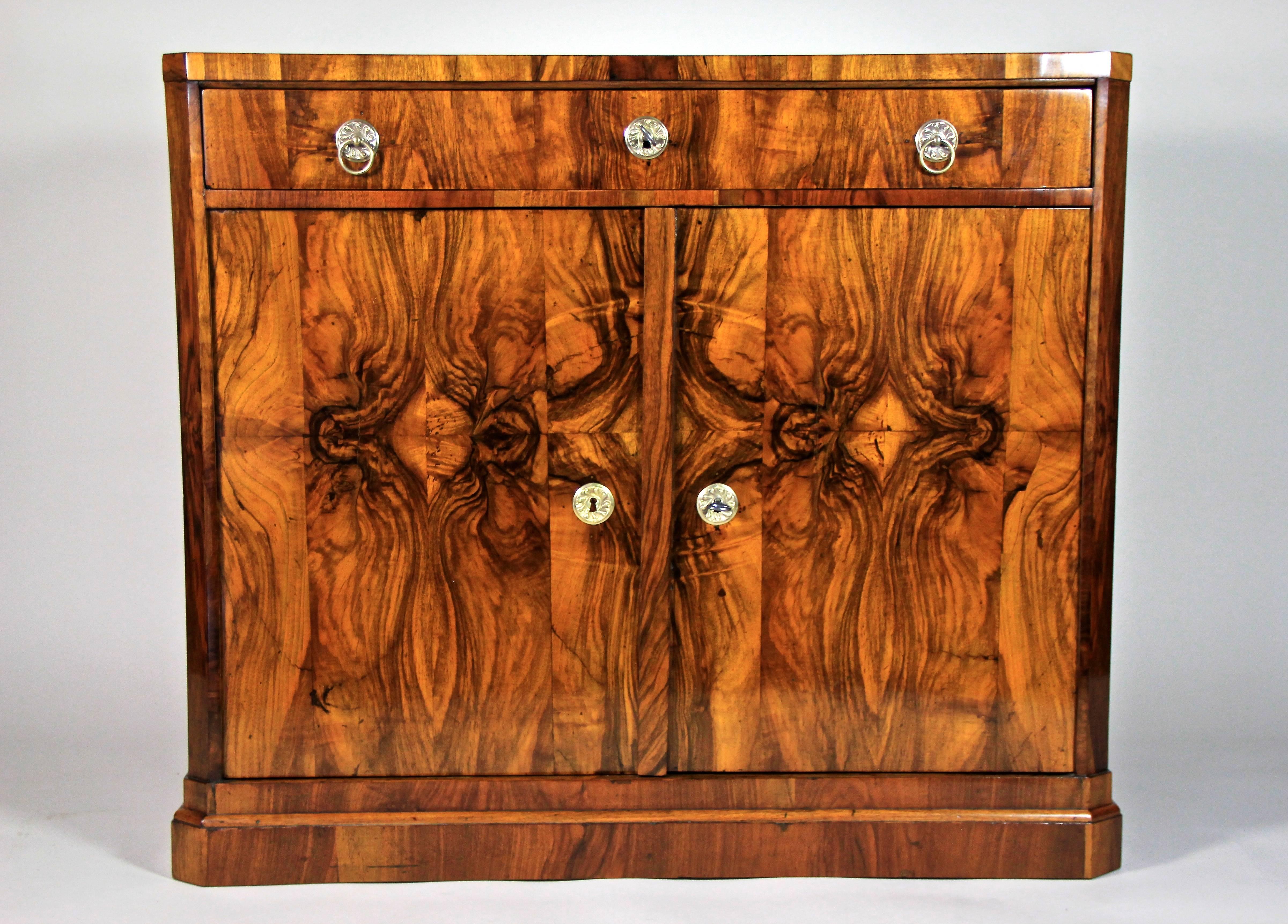 This absolute outstanding Biedermeier trumeau chest was made in South Germany, circa 1825. Reflecting the typical attributes of this period, a clear straight design combining a large drawer above two doors makes this one a real special. Noble brass
