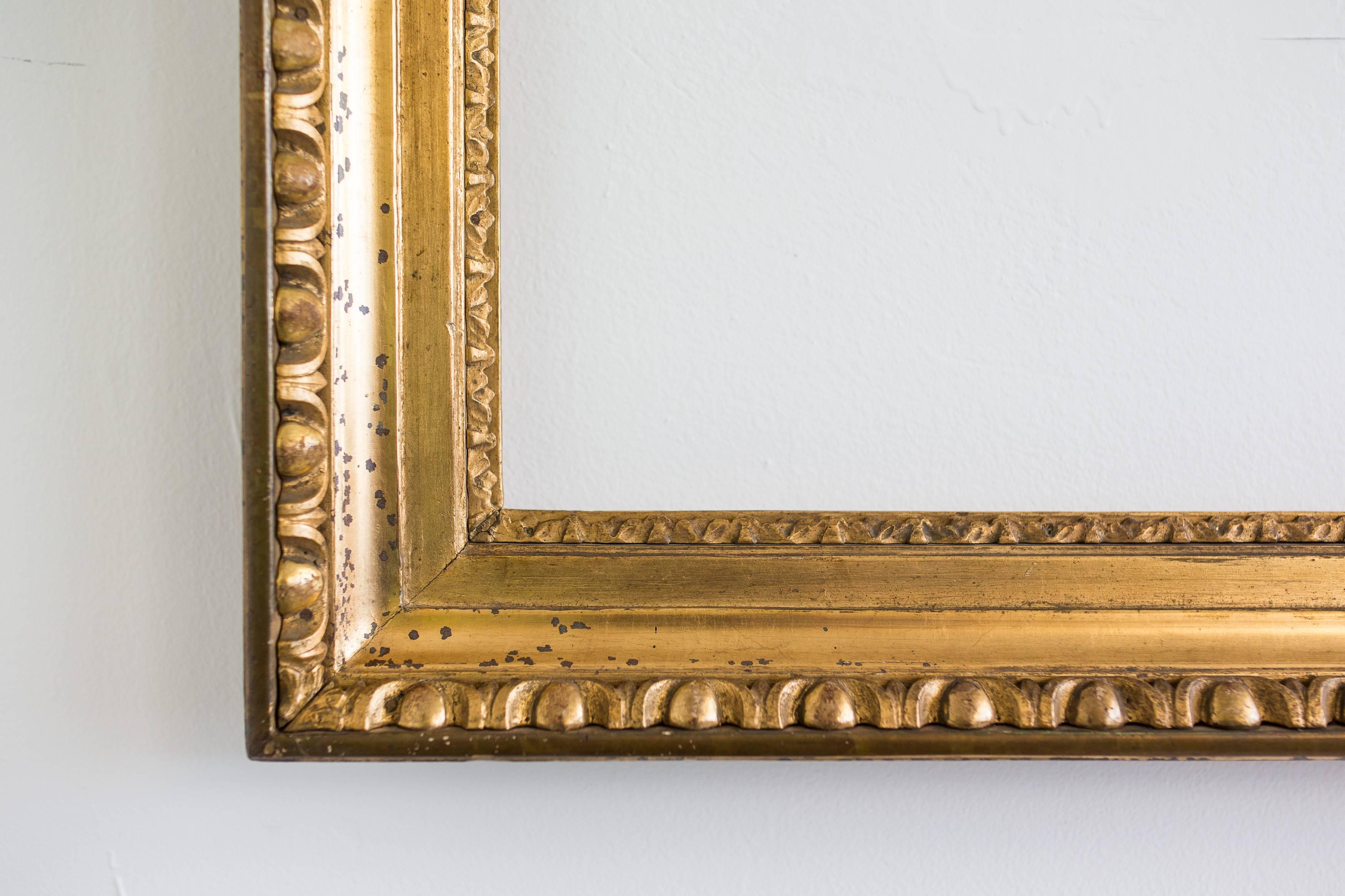 This beautiful big Biedermeier picture frame from the first period, circa 1825, covered with gold leaf on red Bolus, carved stripe and (egg and dart) bullseye motive. The frame has an overlapping inserted sub-structure and is deeply grooved. This