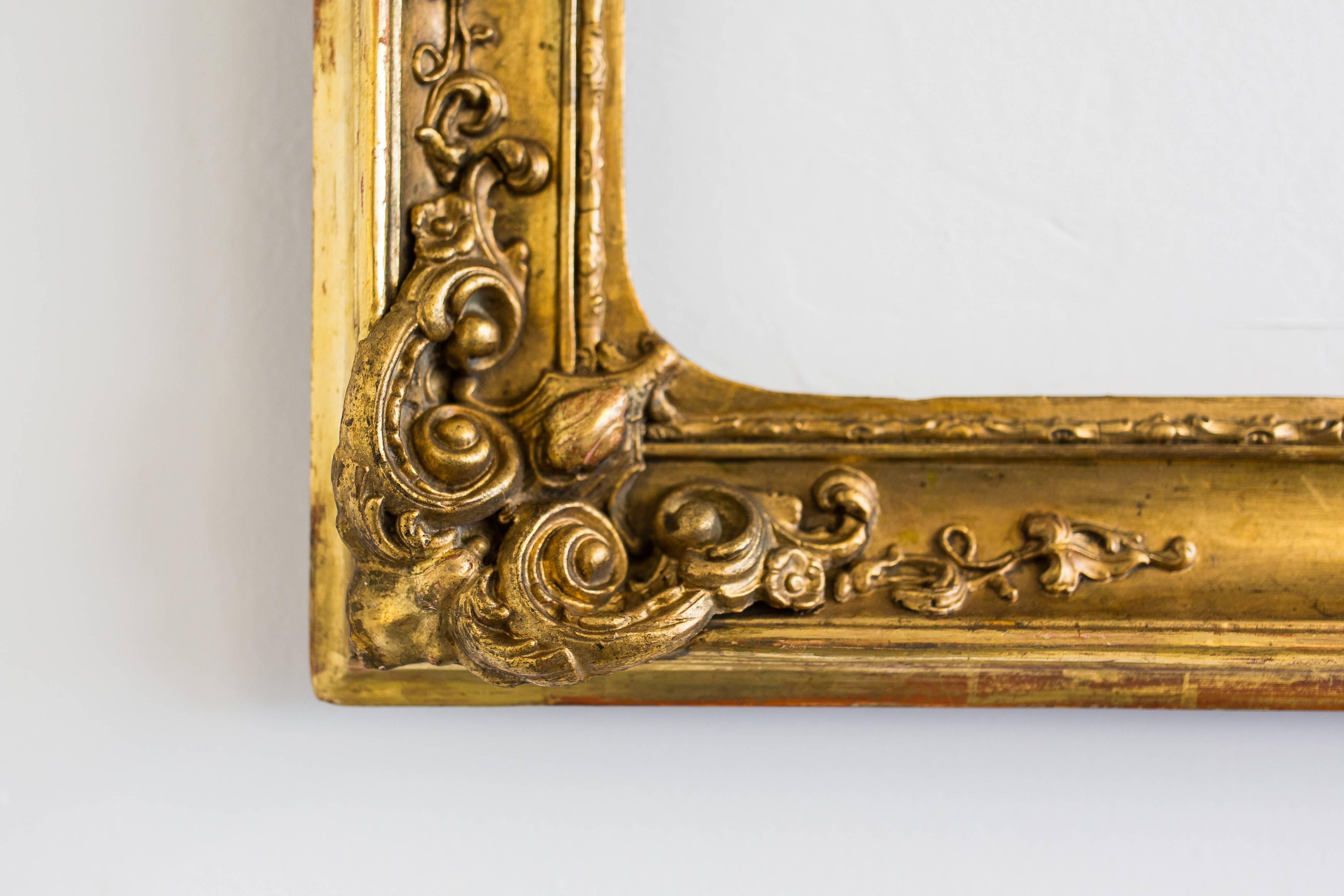 This frame is gold leaf coated on red Bolus, shining through partially and decorated with beautifully floral stucco ornaments.
The frame is in absolute original condition, no former restorations! On the side there are some leftovers of old paper