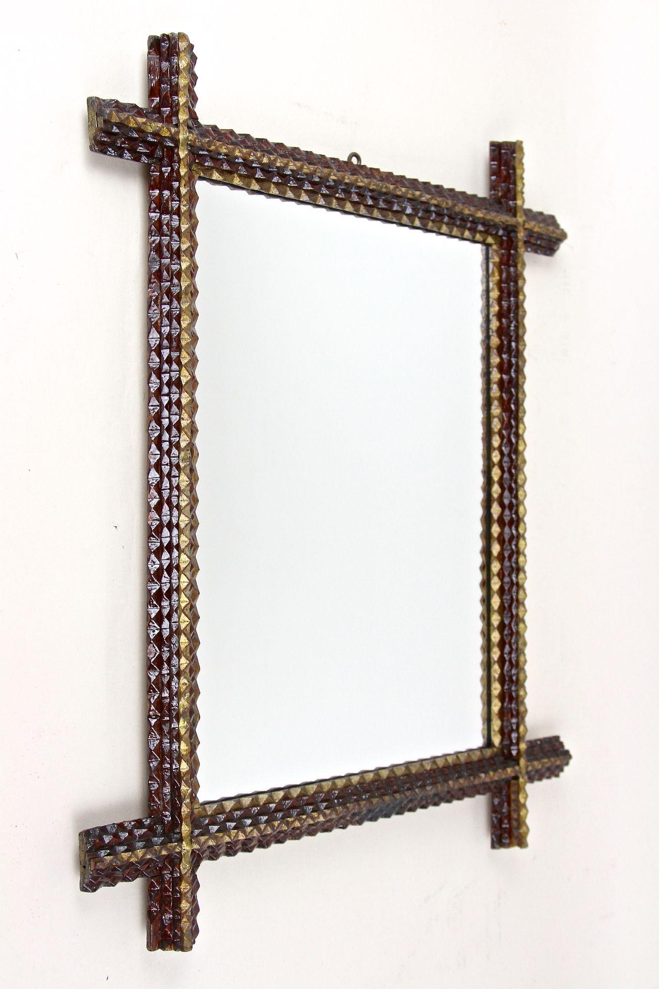 Miroir mural Tramp Art unique, sculpté à la main à la fin du 19e siècle en Autriche. Fabriqué avec art vers 1880, ce magnifique miroir mural rustique impressionne par son extraordinaire design entaillé et ses coins légèrement saillants. Ce cadre