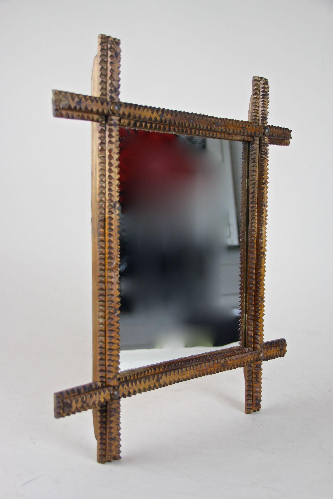 Grazioso specchio da parete Tramp Art rustico intagliato a mano in Austria, risalente al periodo intorno al 1870. Questo piccolo e affascinante specchio in legno della fine del XIX secolo ha una forma classica con angoli leggermente sporgenti e una