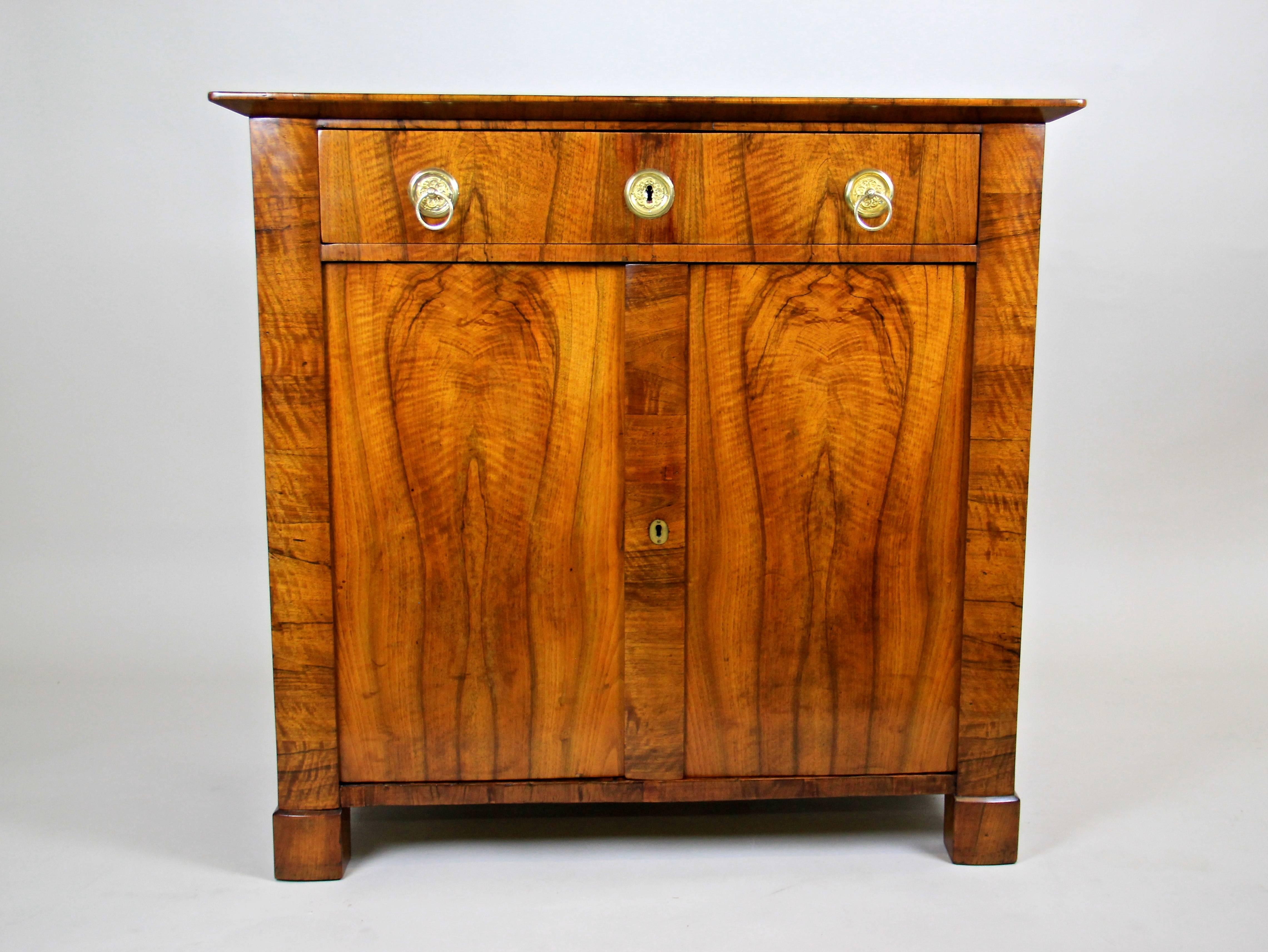 The dreamlike trumeau chest from the Biedermeier period, circa 1830 blends well in any context due to its simple yet charming minimalistic appearance. Constructed from spruce wood and veneered with finest Nutwood for a wonderful allure, this commode