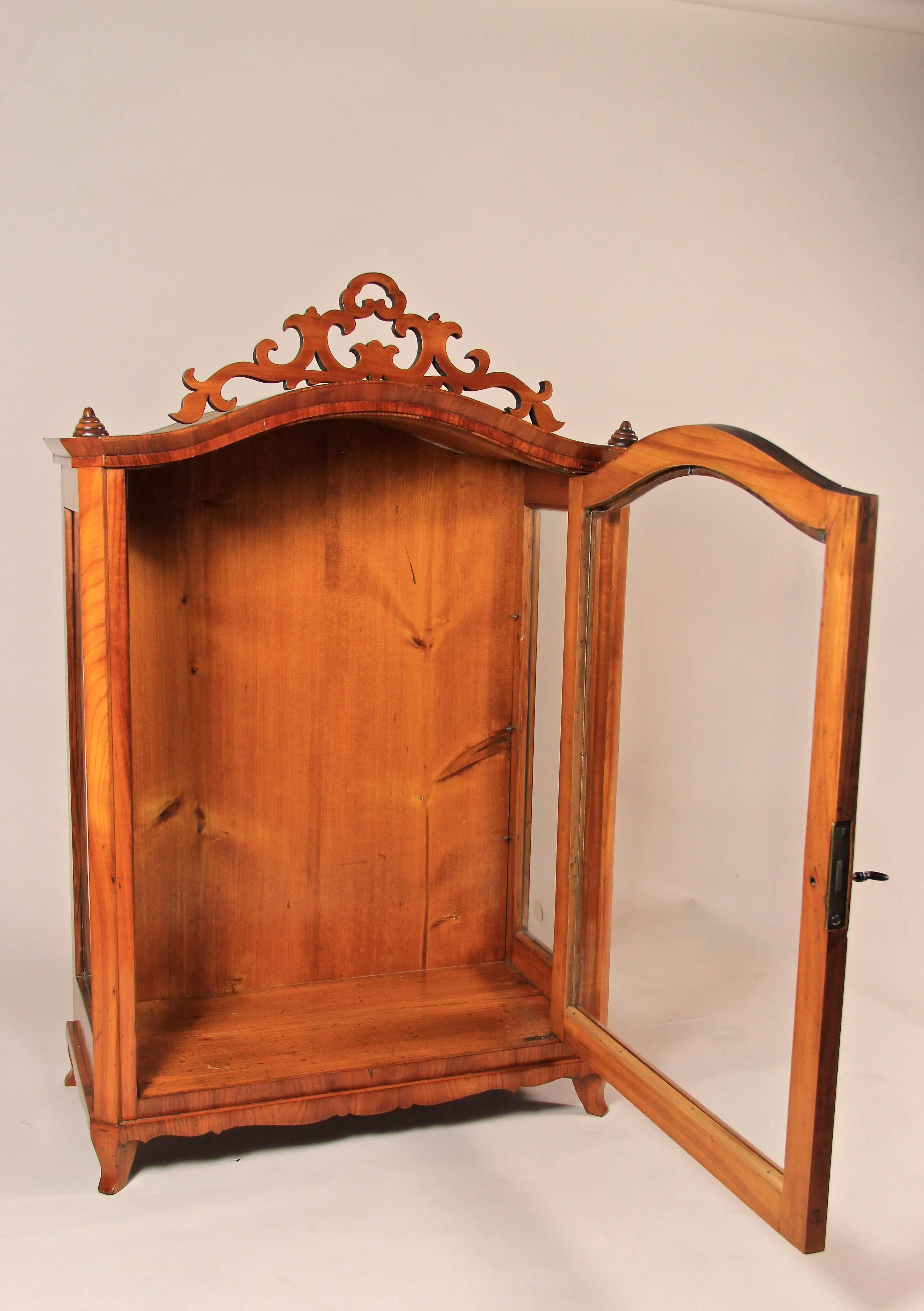 A very decorative smaller table vitrine or display cabinet from the later Biedermeier period circa 1860. Finest cherrywood veneer was used to build this amazing display cabinet, which is glassed on three sides. On top of this beautiful vitrine you