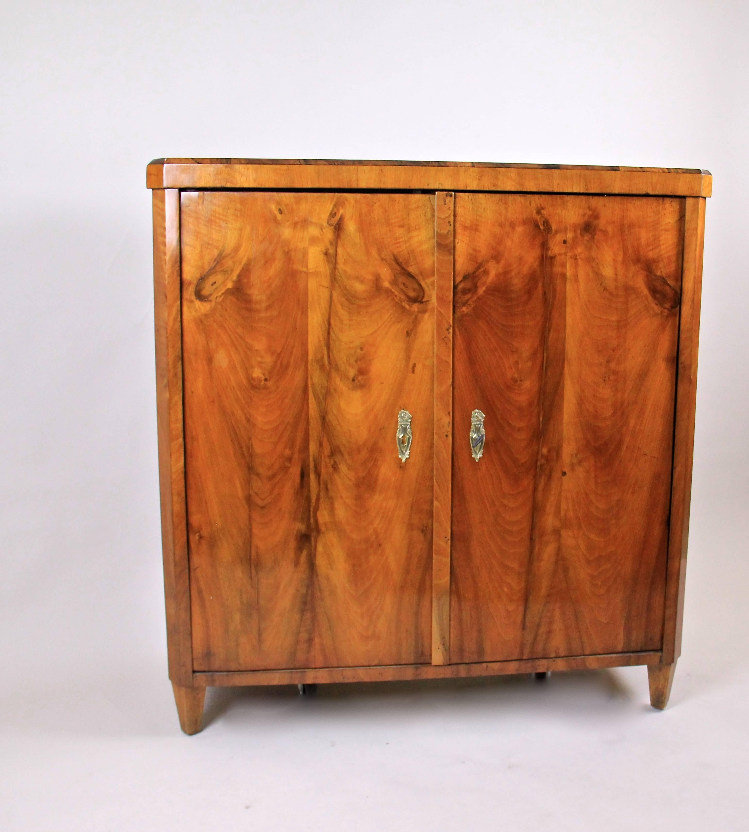 This beautifully arranged half cabinet/sideboard fits effortlessly into any classic or contemporary interior design. Manufactured around 1825, its massive spruce body is topped by a walnut veneer that has been radiantly hand-polished with shellac.