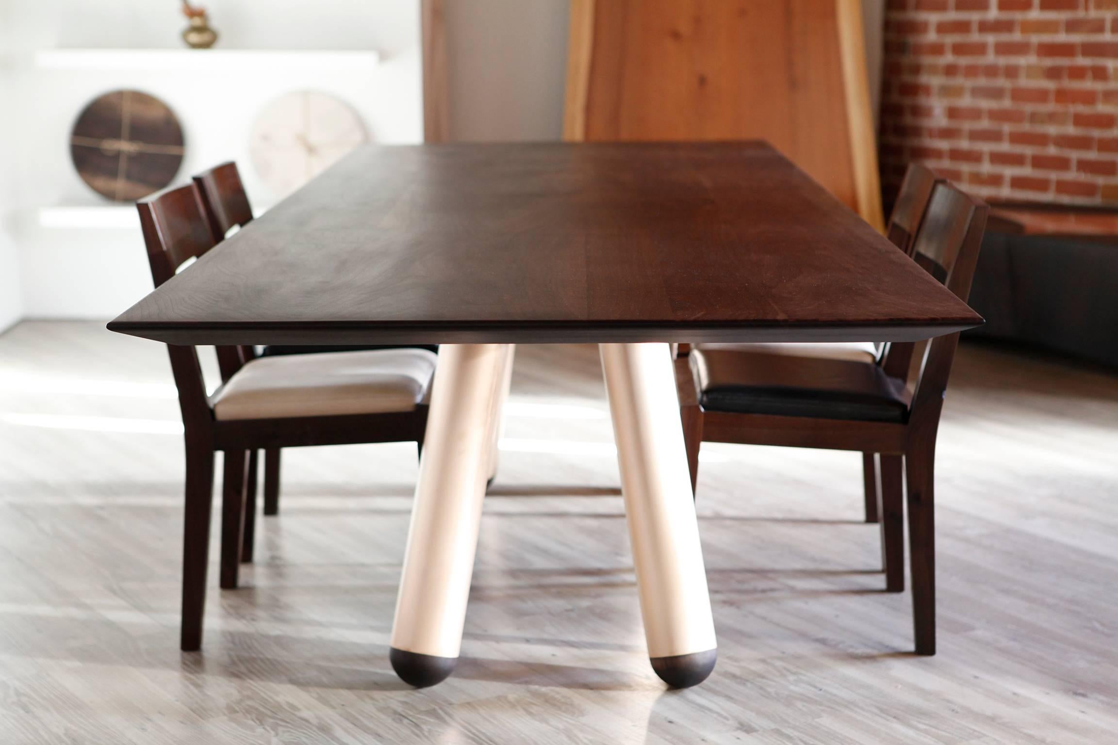 Linee pulite e curve accuratamente selezionate si uniscono per creare un tavolo da pranzo moderno e magistralmente discreto. L'effetto a sbalzo è accentuato dai bordi sagomati a mano, che appaiono sottilissimi grazie all'angolo estremo della