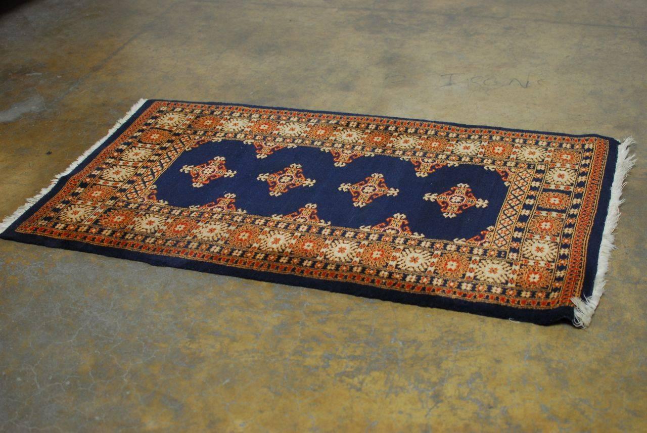 Adorned with intricate border patterns over a navy background. This rug is finely woven with a deep pile and made of natural wool.
