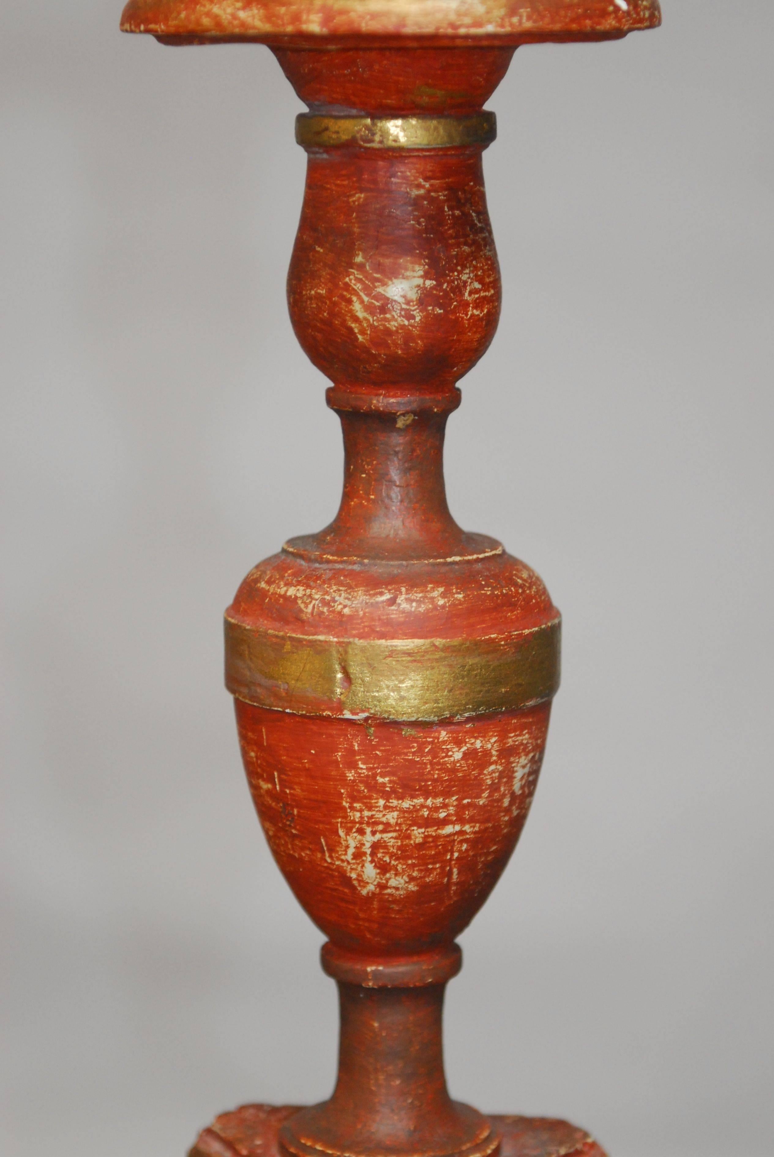 Faux wood Italian altar candlestick made of ceramic and finished in a parcel-gilt polychrome finish. Supported by a tripod footed base. Lovely texture that looks like antique carved wood. Includes a round giltwood finial and no shade.
