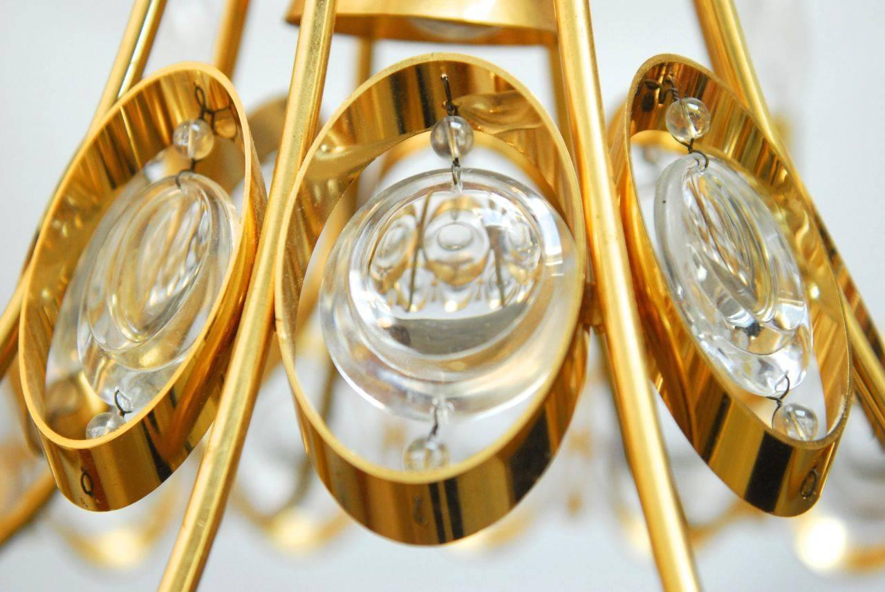 Exquisite chandelier by Palwa featuring a gold-plated brass frame and 40 optical gem like crystals. Mid-Century Modern style made in Germany with eight lights. Includes a ceiling cover in gold.