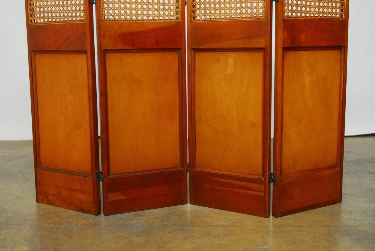 Handsome mahogany screen featuring cane window panels produced by Barnard and Simonds Company, who was purchased by Baker. Mid-Century Modern style with a rich finish on both sides. Small loss on one cane panel as seen in photos.