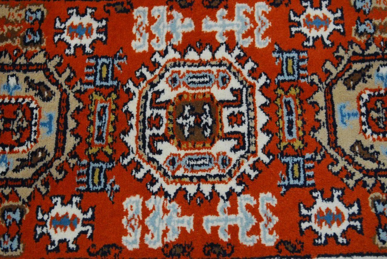 Vibrant tribal style hand-knotted wool carpet featuring multicolored field over a rust ground. Thick high wool pile construction.
 