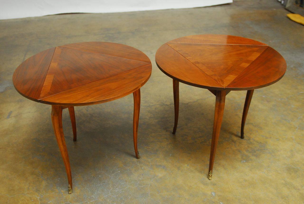 Exquisite pair of drop-leaf tables by Baker featuring a three sided drop-leaf top that fold into triangular shape tables. Constructed of mahogany, each table is made in the Louis XV style. Elegant cabriole legs and decorative brass rocaille feet. 
