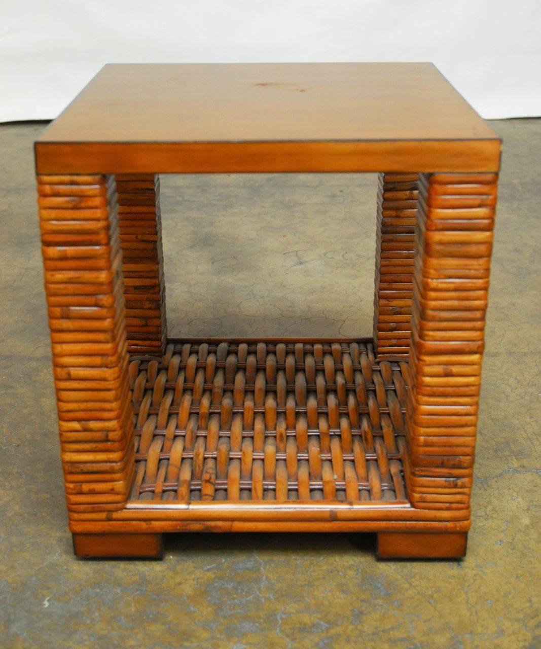 Stylish bamboo end table by Palecek of San Francisco, CA featuring a two-tier shelf with square legs wrapped in shaped bamboo, and a woven bamboo lower shelf. Topped by a walnut slab with a warm finish. Supported by square walnut feet.

