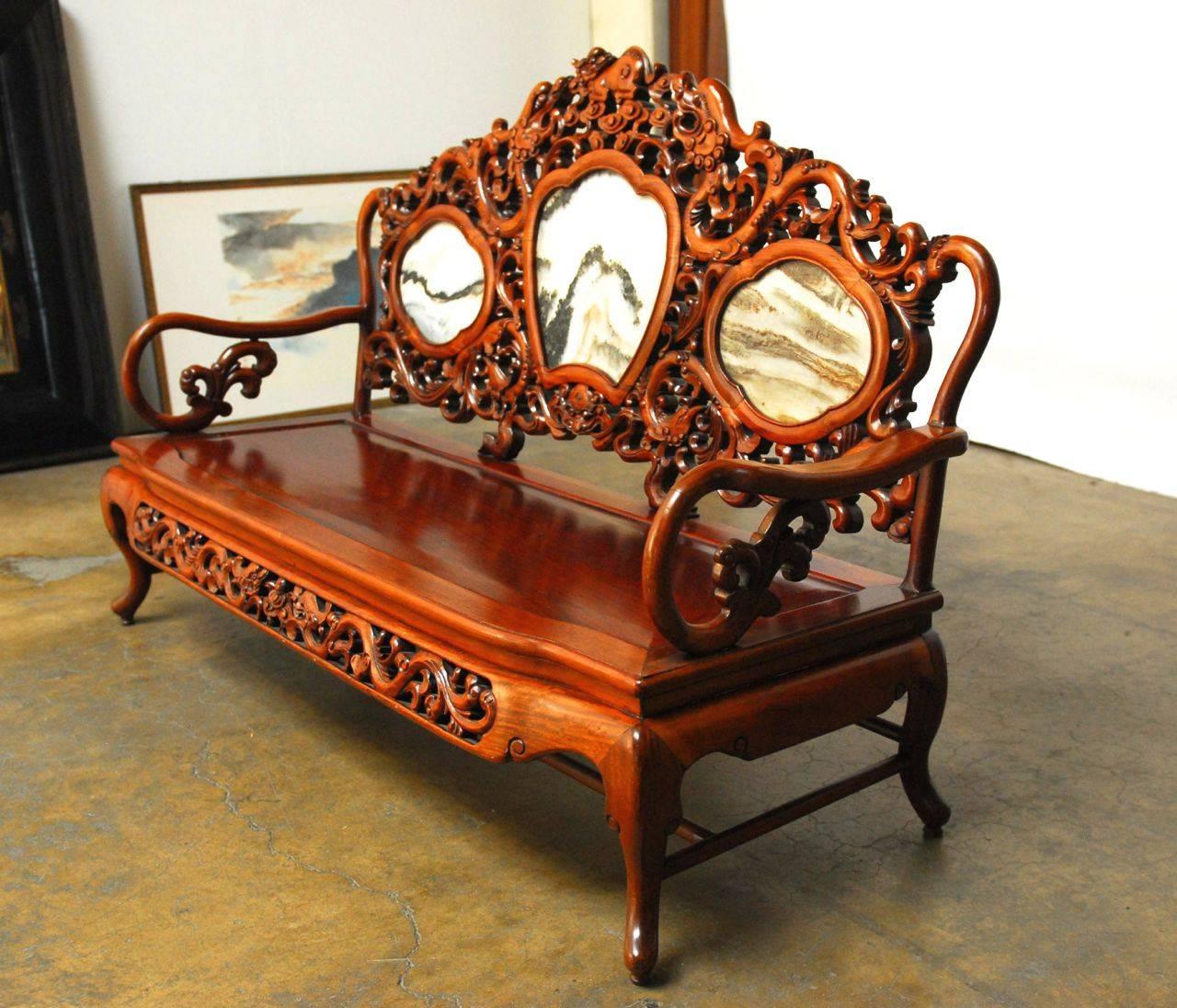 Exquisite hand-carved Chinese bench constructed of solid mixed rosewood and hardwood. High relief carvings of dragons, mythical beasts, phoenix and decorative elements. Centered on the back by three Chinese marble Dali or dreamstone panels meant to