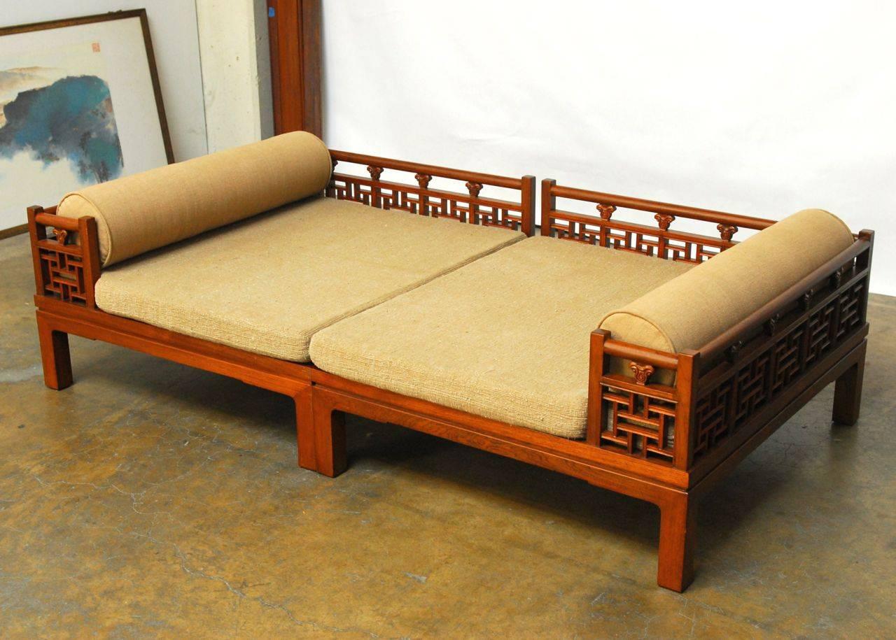 Gorgeous and intricately carved low daybed or Luohan constructed of solid teak in British Colonial Hong Kong. Detailed geometric fretwork and carving adorns this unusual sectional piece throughout. Modular design also allows use as a pair of low