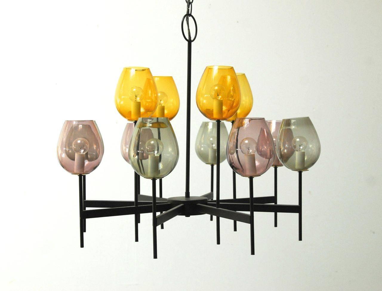 Extremely rare Mid-Century chandelier features a Minimalist architectural form of eight arms from which twelve rods extend. Each surmounted by a light with a handblown glass tulip cover in either smoked, amber, or lavender color. Top quality
