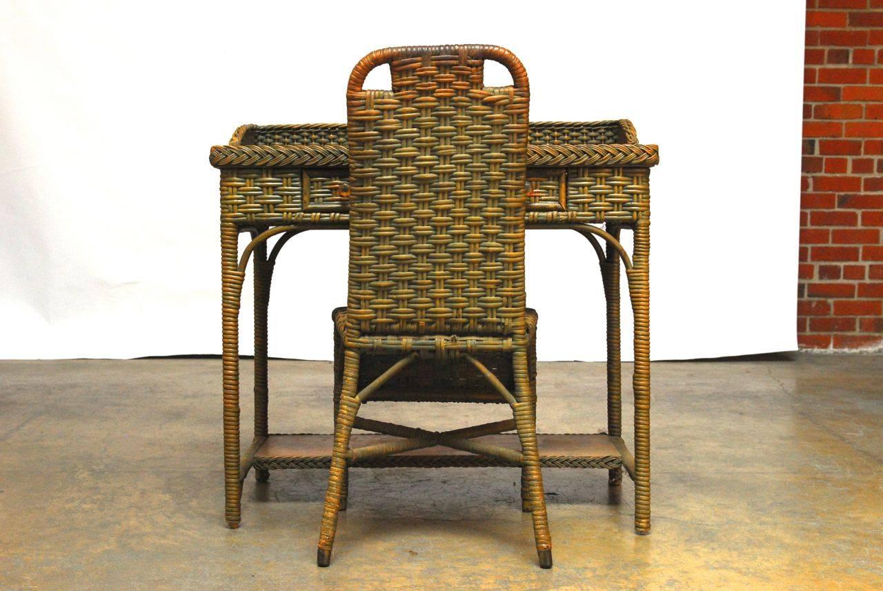 Fabulous antique French hardwood framed wicker desk and chair with a lovely distressed green finish. This desk has a Primitive unpainted oak top and has excellent character throughout the woven split rattan. Architectural elements such as gracing