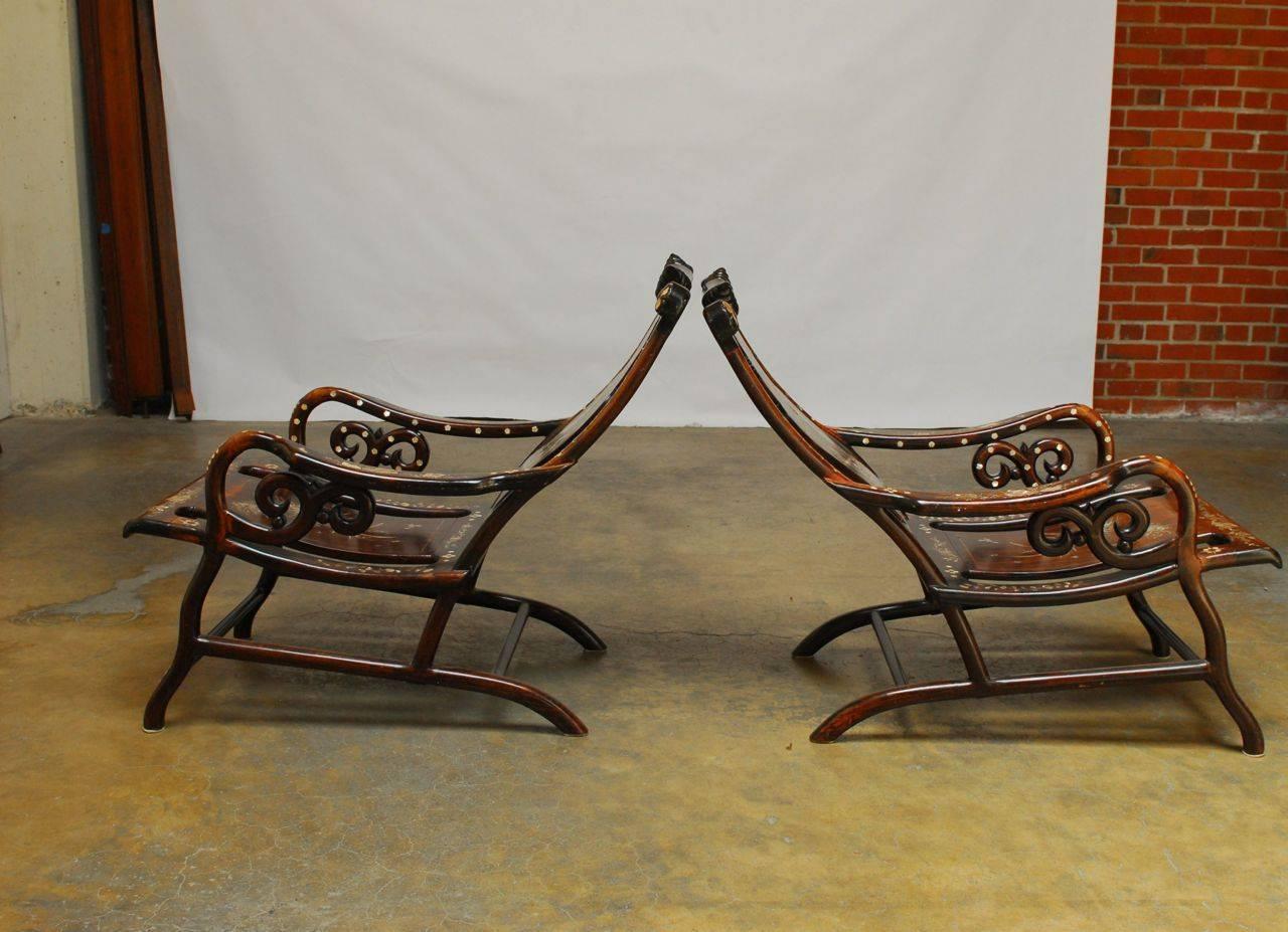 Pair of unusual and elegant reclined rosewood lounges featuring extremely ornate hand laid mother-of-pearl insets. With great detail these inlays depict mirrored naturalistic scenes on the seats and a scholars botanical desk arrangement on the back