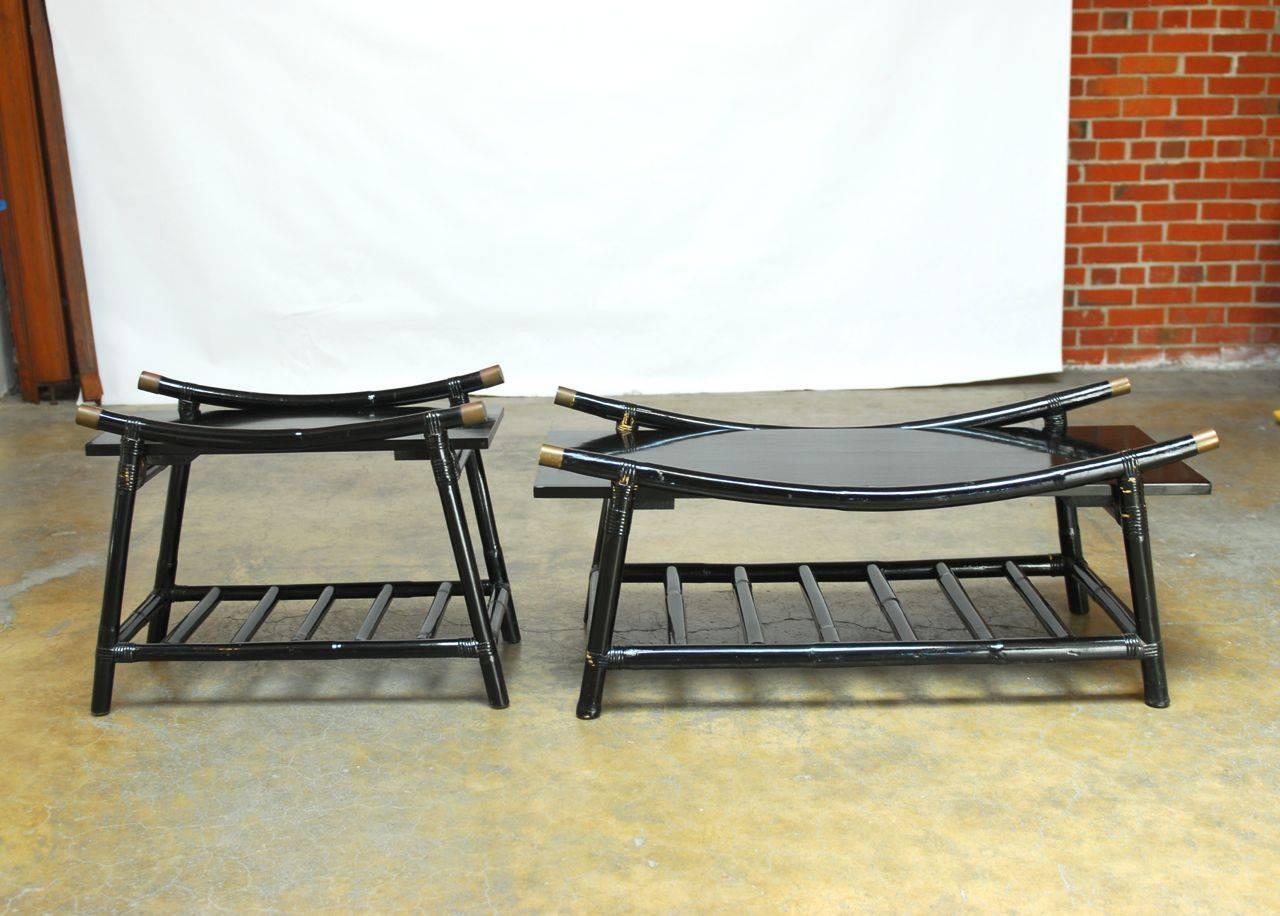Ficks Reed Modern black lacquer rattan coffee table and side table with brass accent caps. Featuring ladder style magazine shelves and striking crescent form tops. Exceptional midcentury pieces that have a Japanese style bamboo construction.